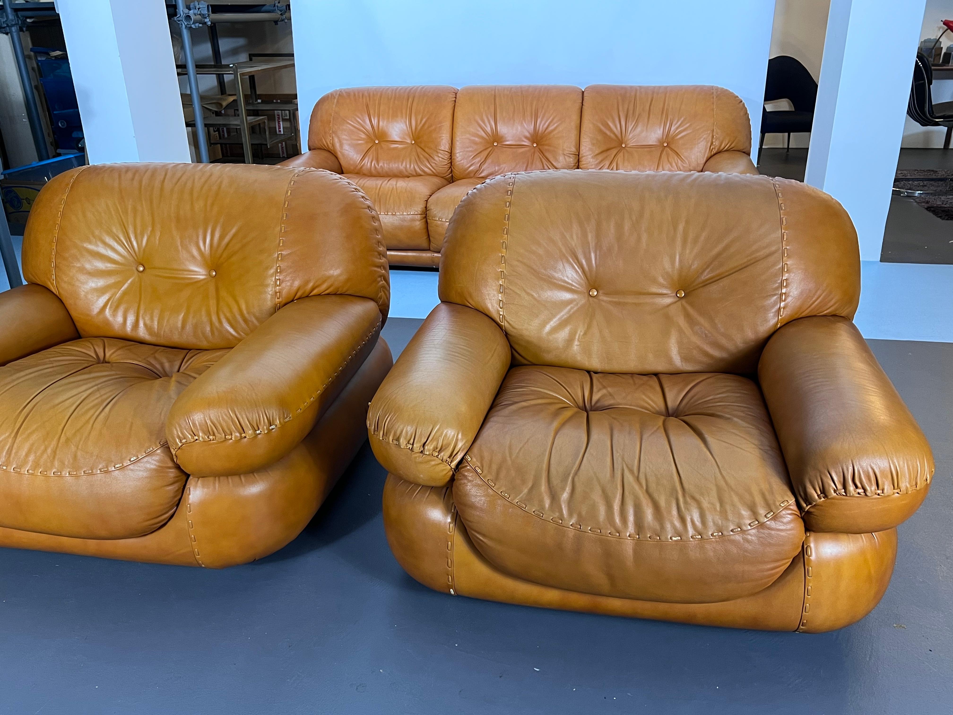Set of two armchairs and a three seater sofa designed by Sapporo for Mobil Girgi. Cognac leather. Original vintage condition with normal trace of age and use. Foam in perfect condition. No damages. Dimensions: Sofa H 75 W 225 D 100, Armchair H 75 W