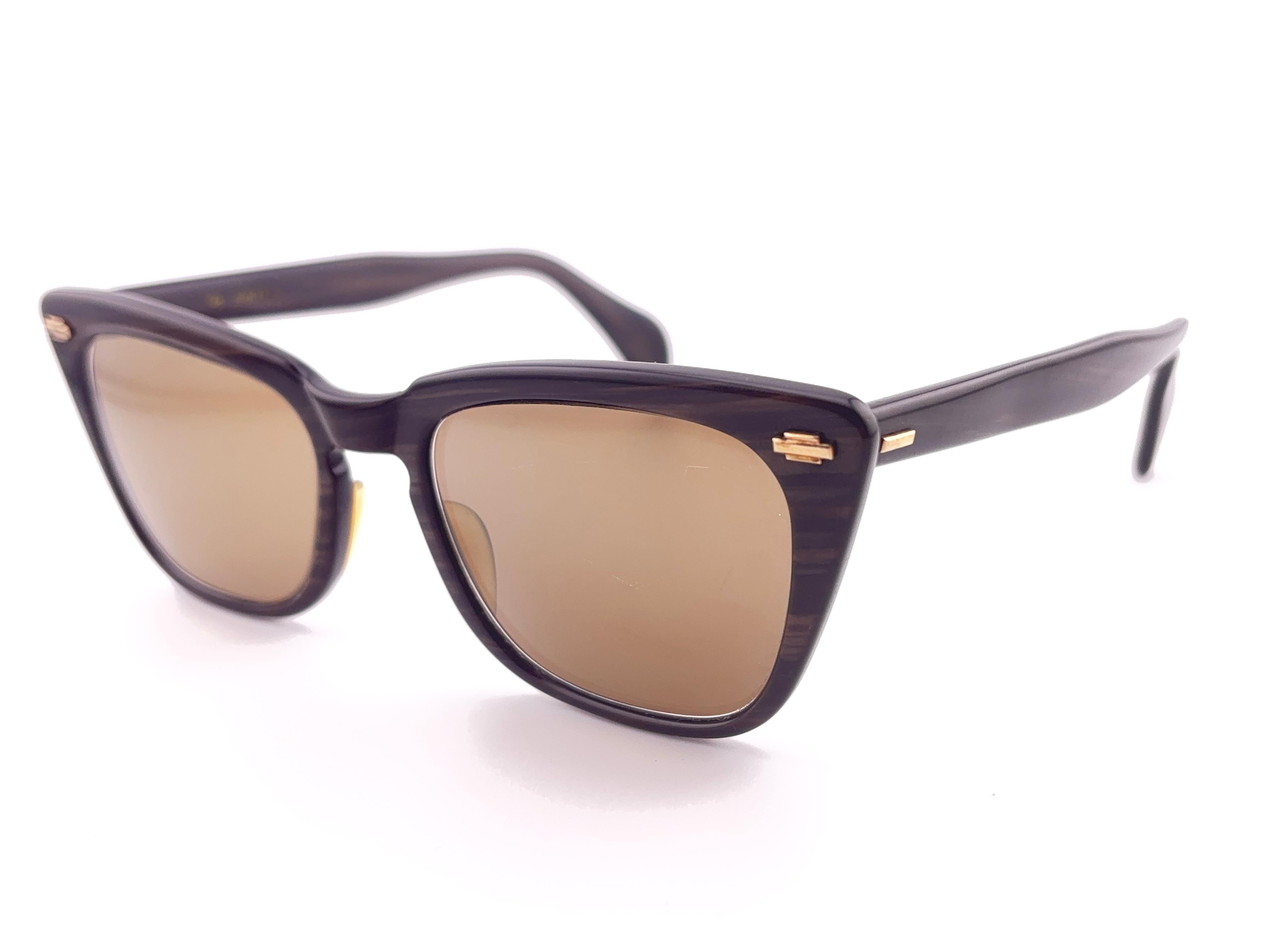 Ultra raro paio di occhiali da sole vintage Solaris degli anni '60 da collezione
Montatura leggera a righe marrone scuro con dettagli dorati, con lenti a specchio chiare.
Questa coppia mostra segni visibili di usura sia sulle lenti che sulla