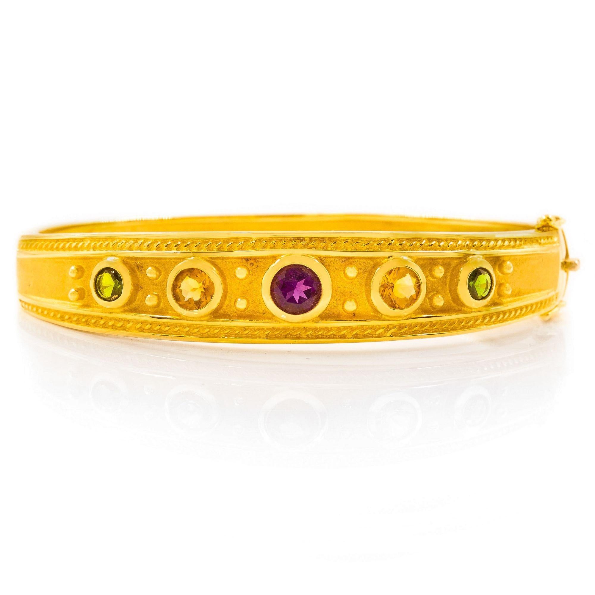 A FINELY CAST SOLID 14 KARAT GOLD GEMSET BANGLE BRACELET
Item # C104266

An exquisite solid 14 karat yellow gold bracelet, the body is cast with a wonderful variation of textures and three-dimensional elements: the lowest ground of the bracelet is a