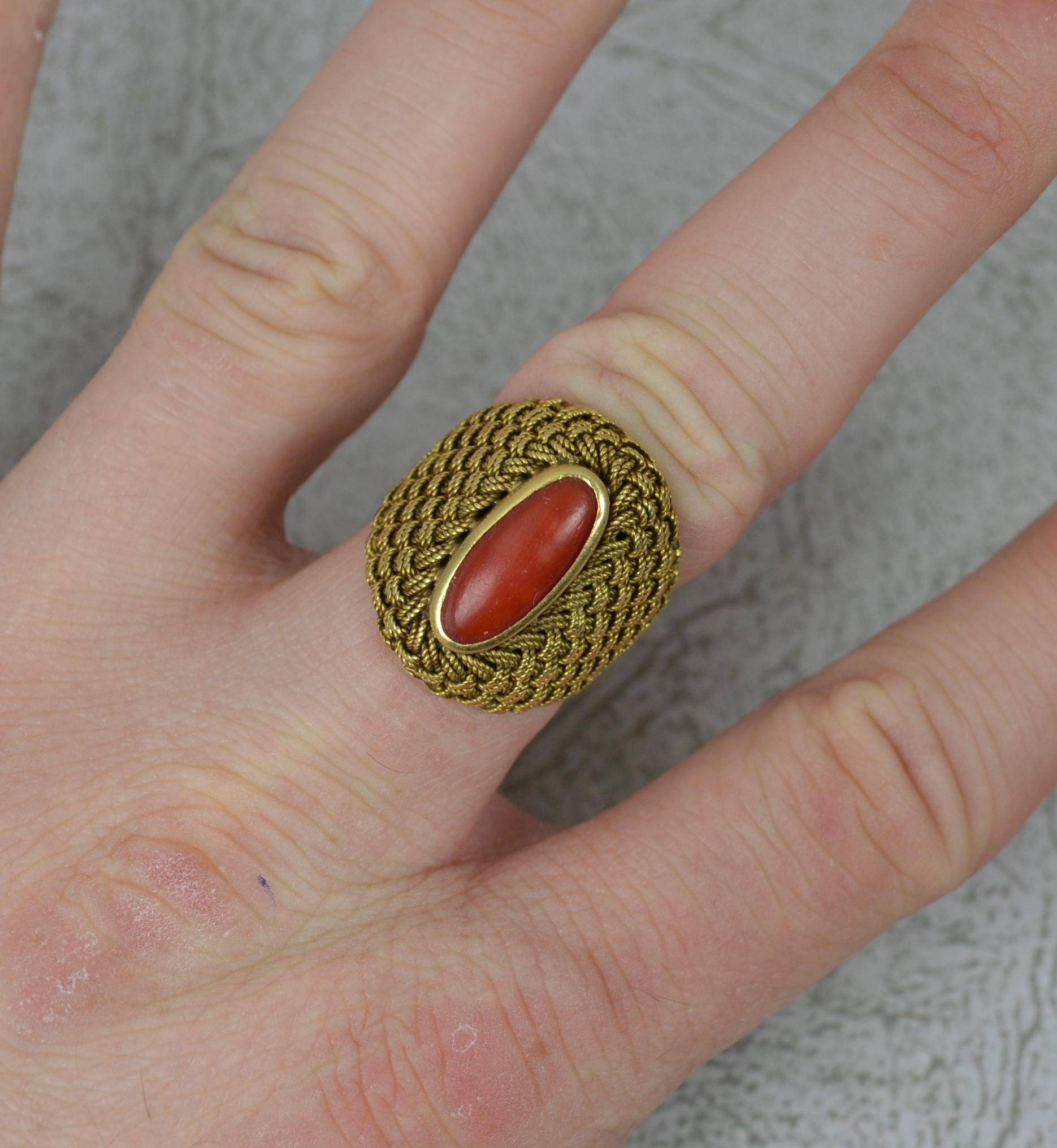 A superb quality vintage ring, circa 1970.

Solid 18 carat yellow gold example.

Designed with a single, oval shaped coral. 5mm x 13mm in full bezel setting. 

A fine braided pattern throughout the head.


CONDITION ; Very good. Clean, solid band.