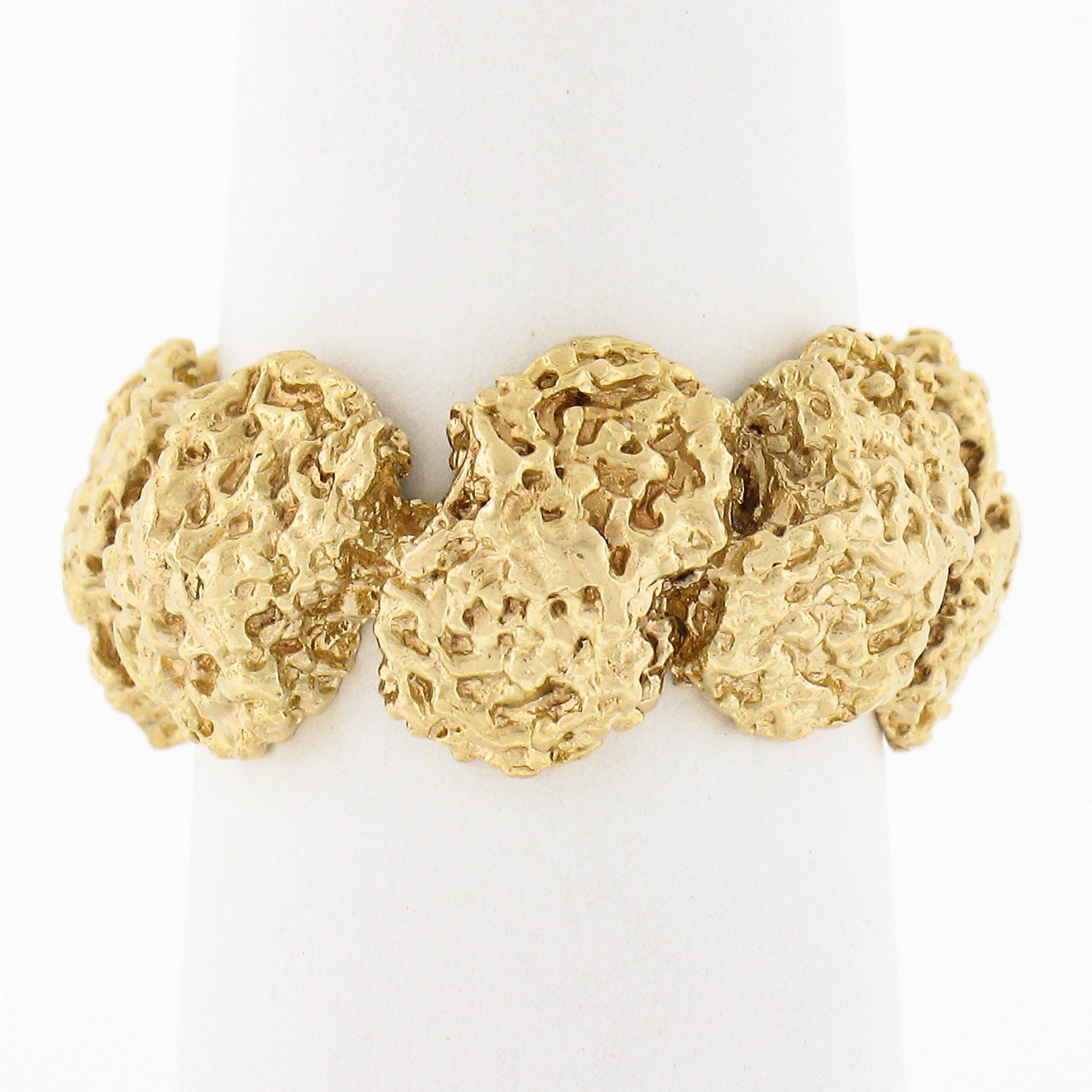 This beautiful and well made vintage ring was crafted from solid 18k yellow gold and features a lovely textured nugget design that runs entirely around the band, creating a bold, very unique, and attractive look on the finger. The wide band remains