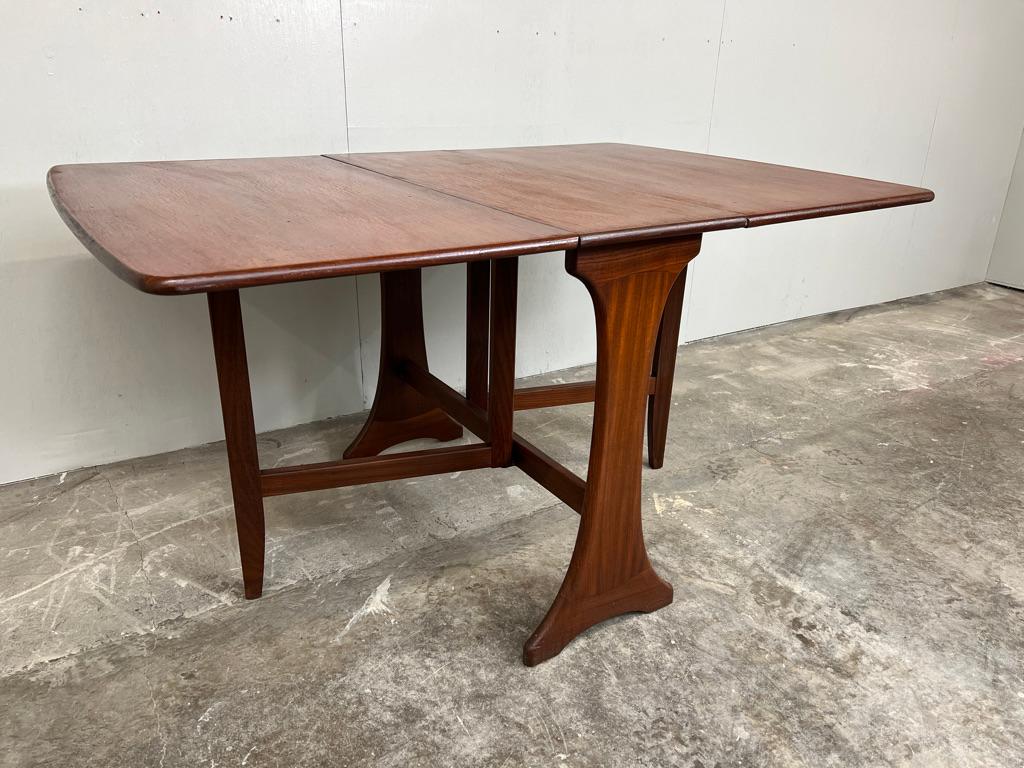 Il s'agit d'une table de salle à manger en teck danois de qualité, avec de superbes pieds en forme, et les deux feuilles sont un excellent gain de place, idéal pour un petit appartement ou un condominium.

Cette élégante table à abattant en teck