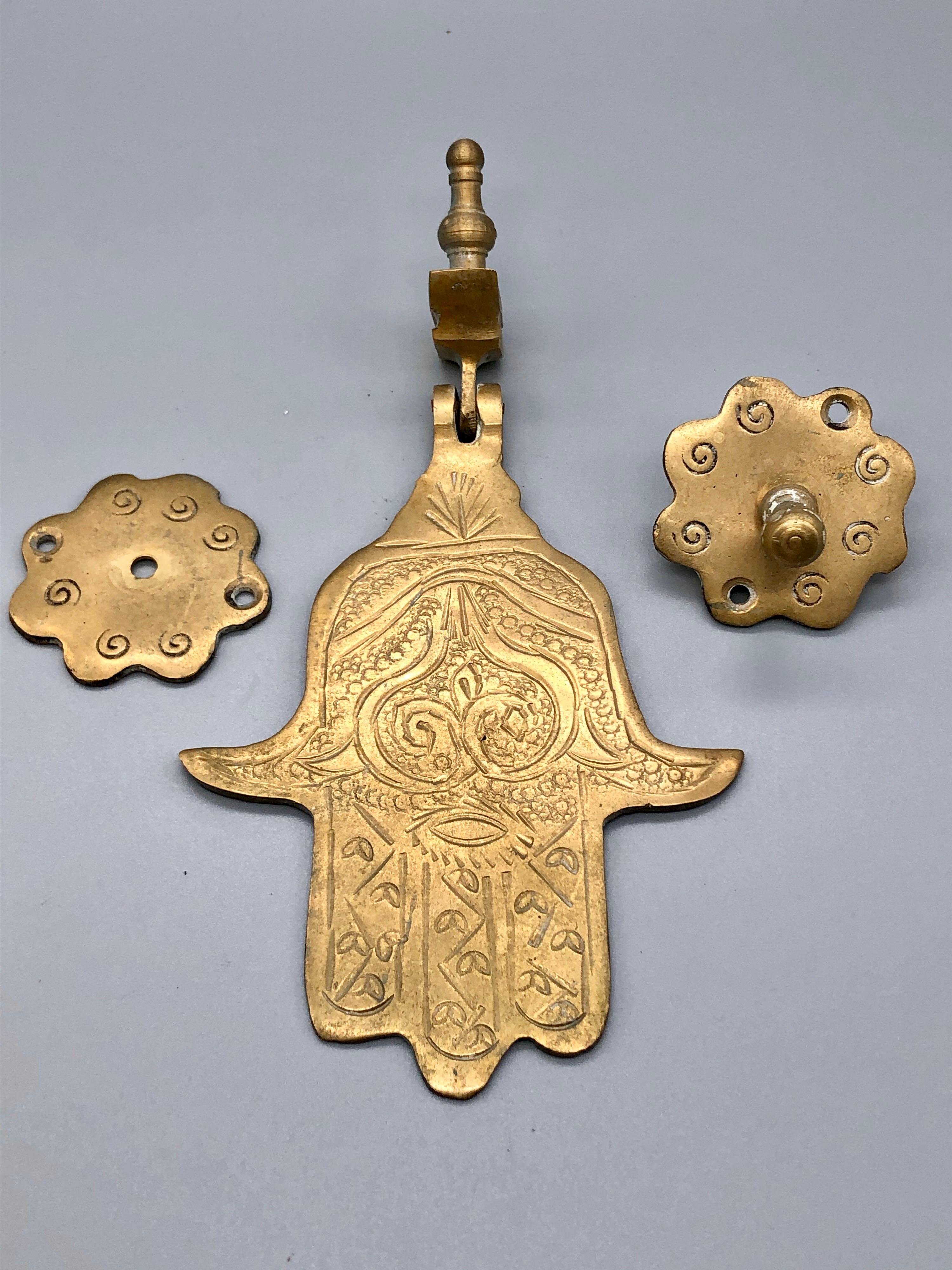 Handcut vintage brass Hamsa from Morocco circa 1950. Hand-engraved with traditional Berber symbols: tree of life, Sahara desert tent, evil eye, spiral of life. 

Affixes to door using included hardware. For thicker doors a larger screw can be