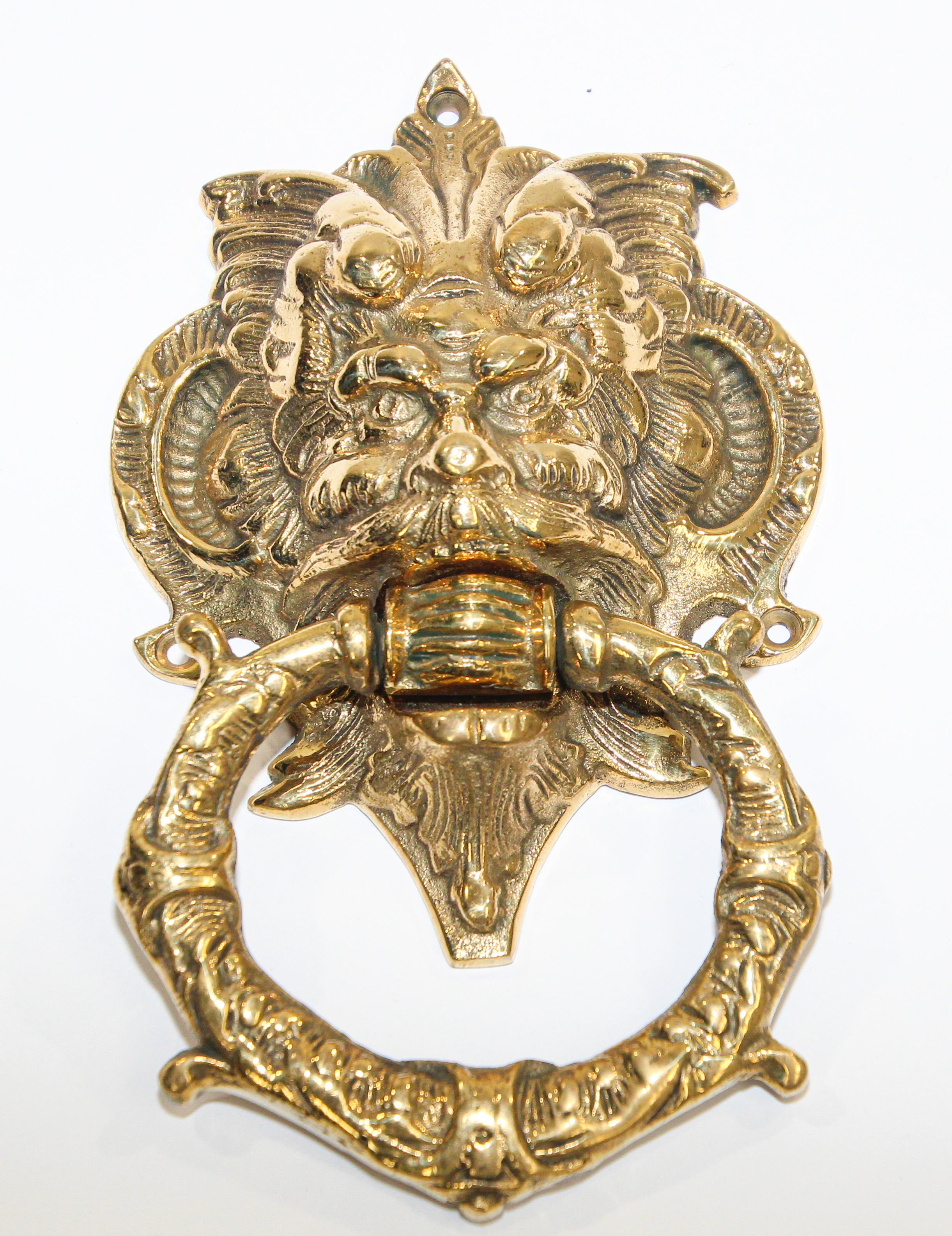 Vintage solid cast brass Italian door knocker with scary evil devil man face.
The large mascaron crest has been crafted in grotesque style and is sometimes called a chimera. 
A mascaron is an architectural ornamentation, typically a face, that is