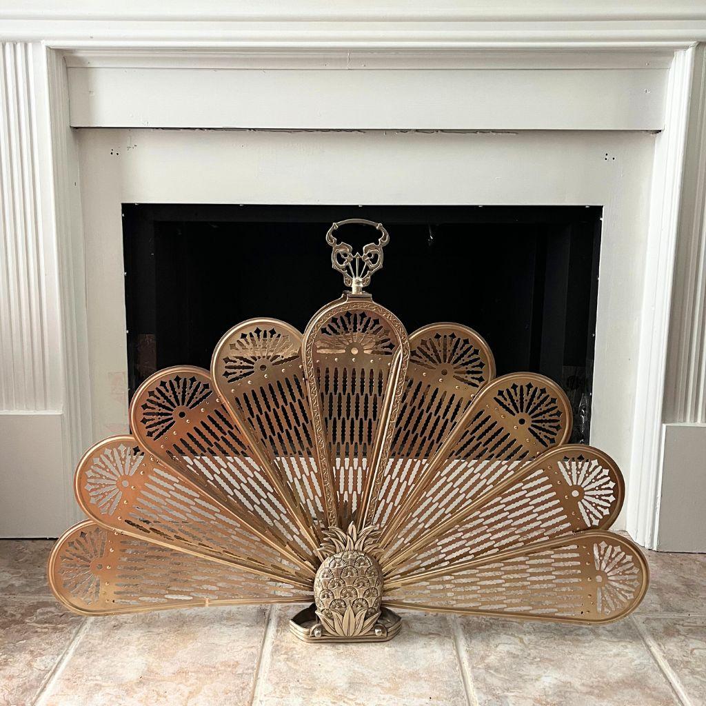 Faites-vous remarquer avec cet écran de cheminée ananas en laiton vintage, une pièce magnifiquement fabriquée qui incarne la chaleur, la sophistication et l'hospitalité intemporelle. Les pales du ventilateur, percées de façon complexe, laissent