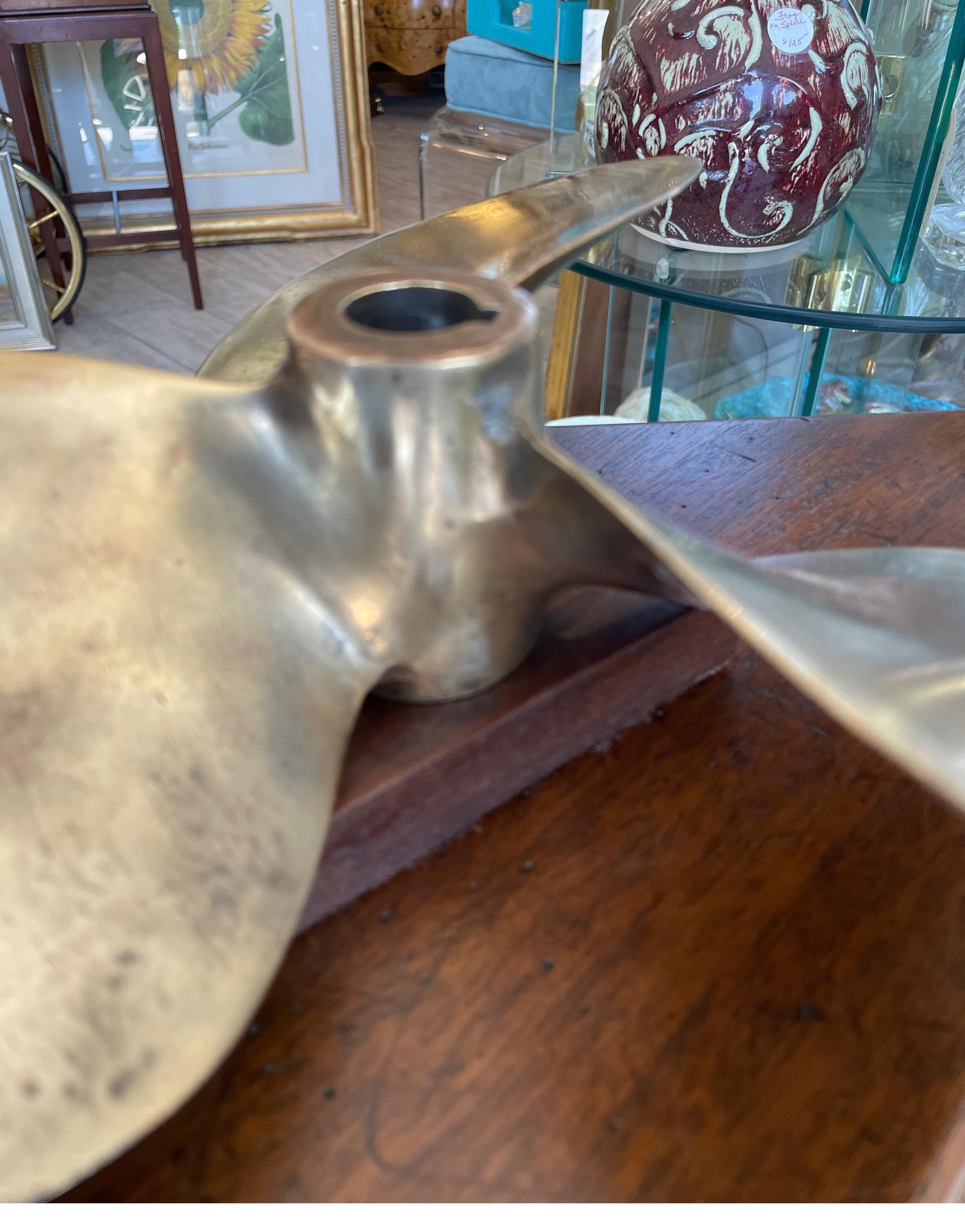 Vintage solid brass boat propeller mounted on a wood base. This nautical piece makes a perfect desk accessory / paperweight.