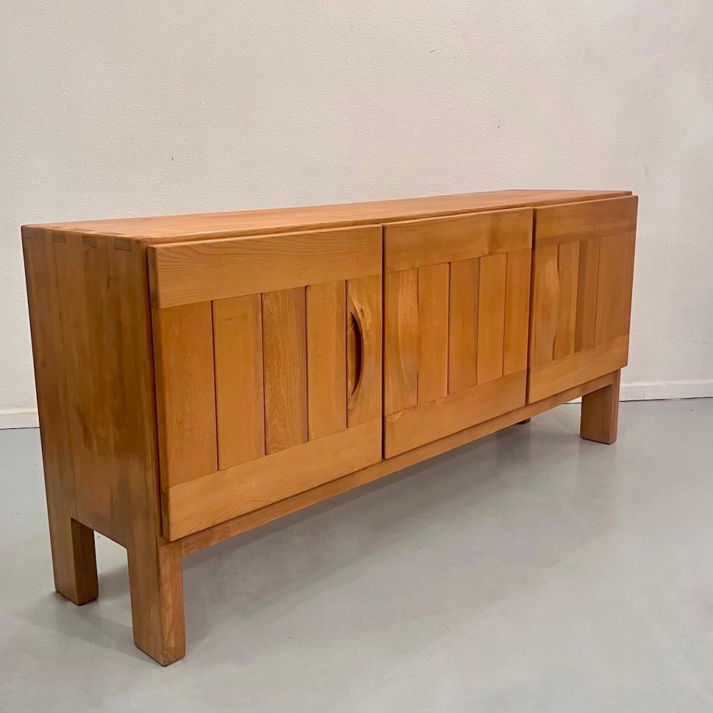Beautiful vintage solid elm sideboard manufactured by Maison Regain in France ca. 1960s
Hand curved handles for this high quality piece of furniture, in very good original condition.
Shelves on the left side, two drawers on the right.

