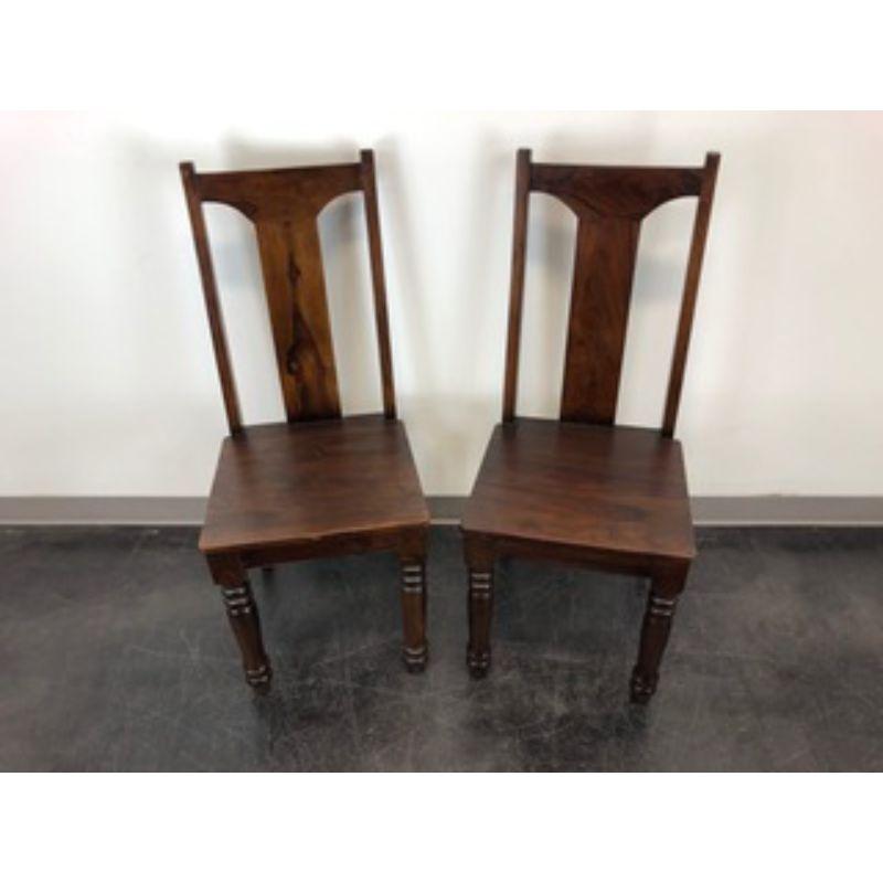 A pair of British Colonial style dining side chairs, unbranded. Mango wood with solid crest rail, backsplat & seat, turned front legs and curved back legs. Made in the USA, in the mid 20th Century. 

Measures: Overall: 17.75W 20.5D 42H, Seats: