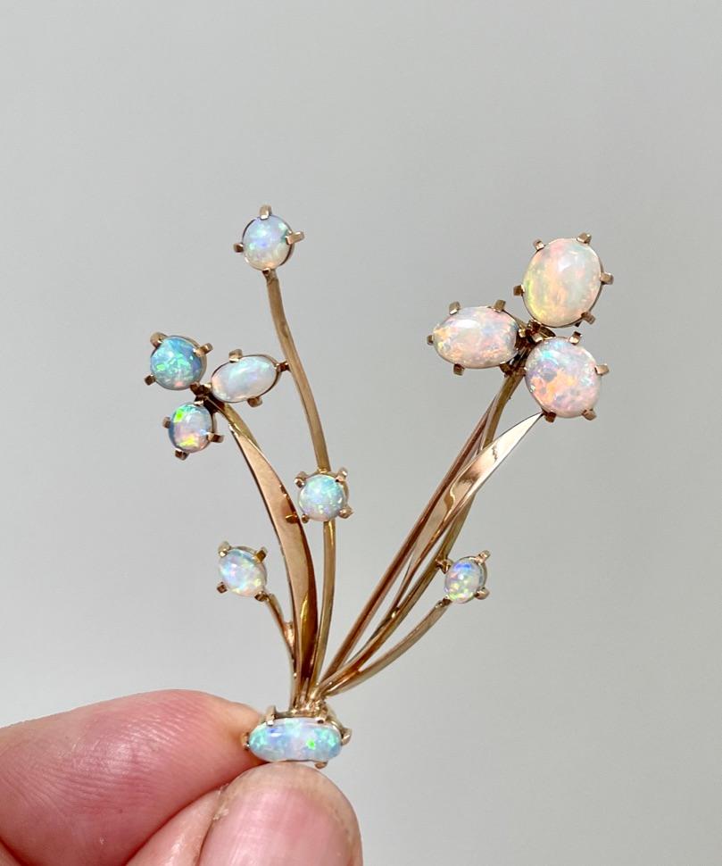 This is a very high quality vintage piece.  
You will understand when you hold it and feel the smooth and silky lines.  The photos cannot do it justice.

It features lovely, Australian solid Opals that are set on 15ct yellow gold stems to look like