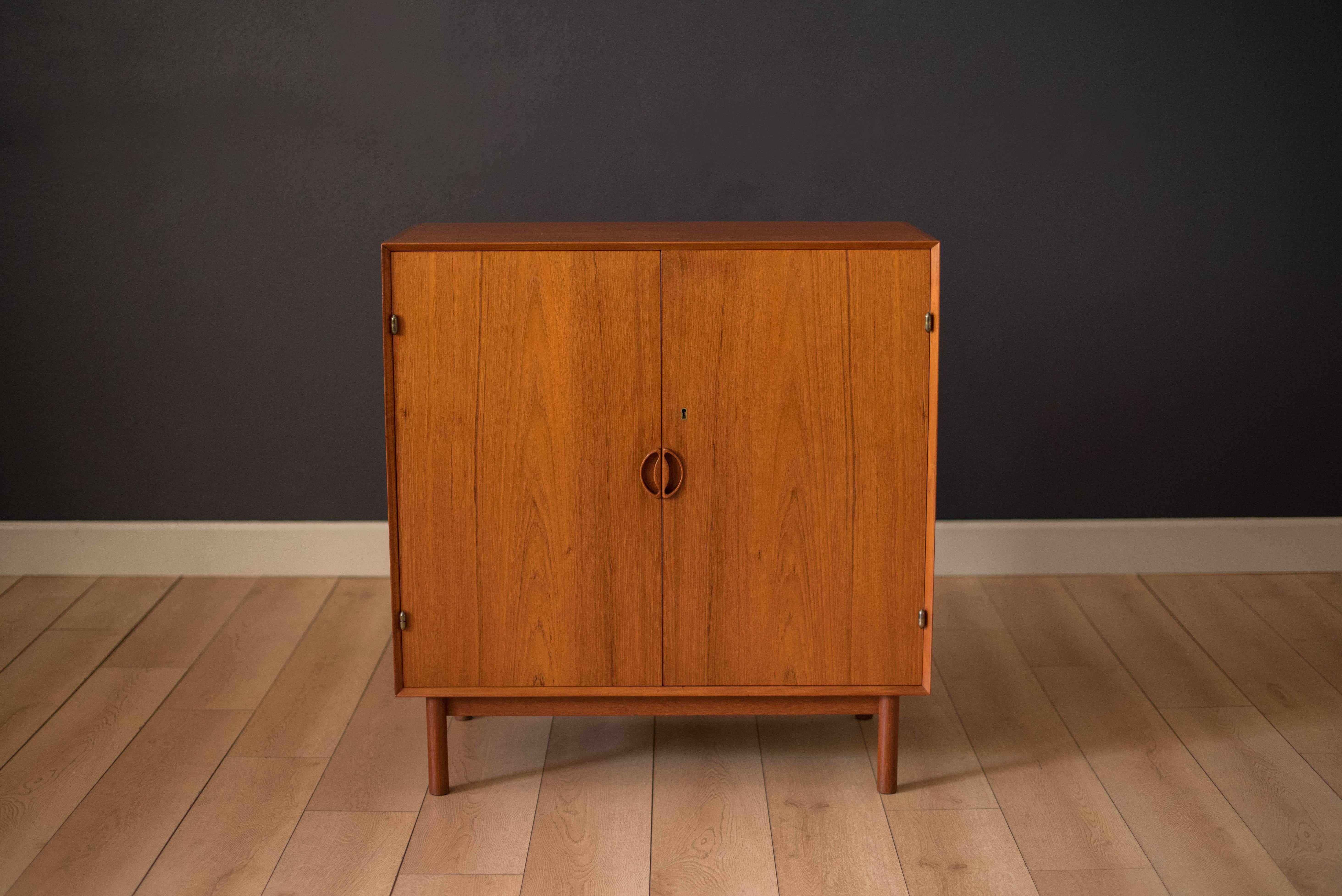 Mid-Century teak cabinet by Peter Hvidt and Orla Mølgaard-Nielsen for Søborg Møbler. This piece displays detailed finger joinery and sculpted wood handles. Interior of cabinet features three sliding drawers and one adjustable shelf. Skeleton key is