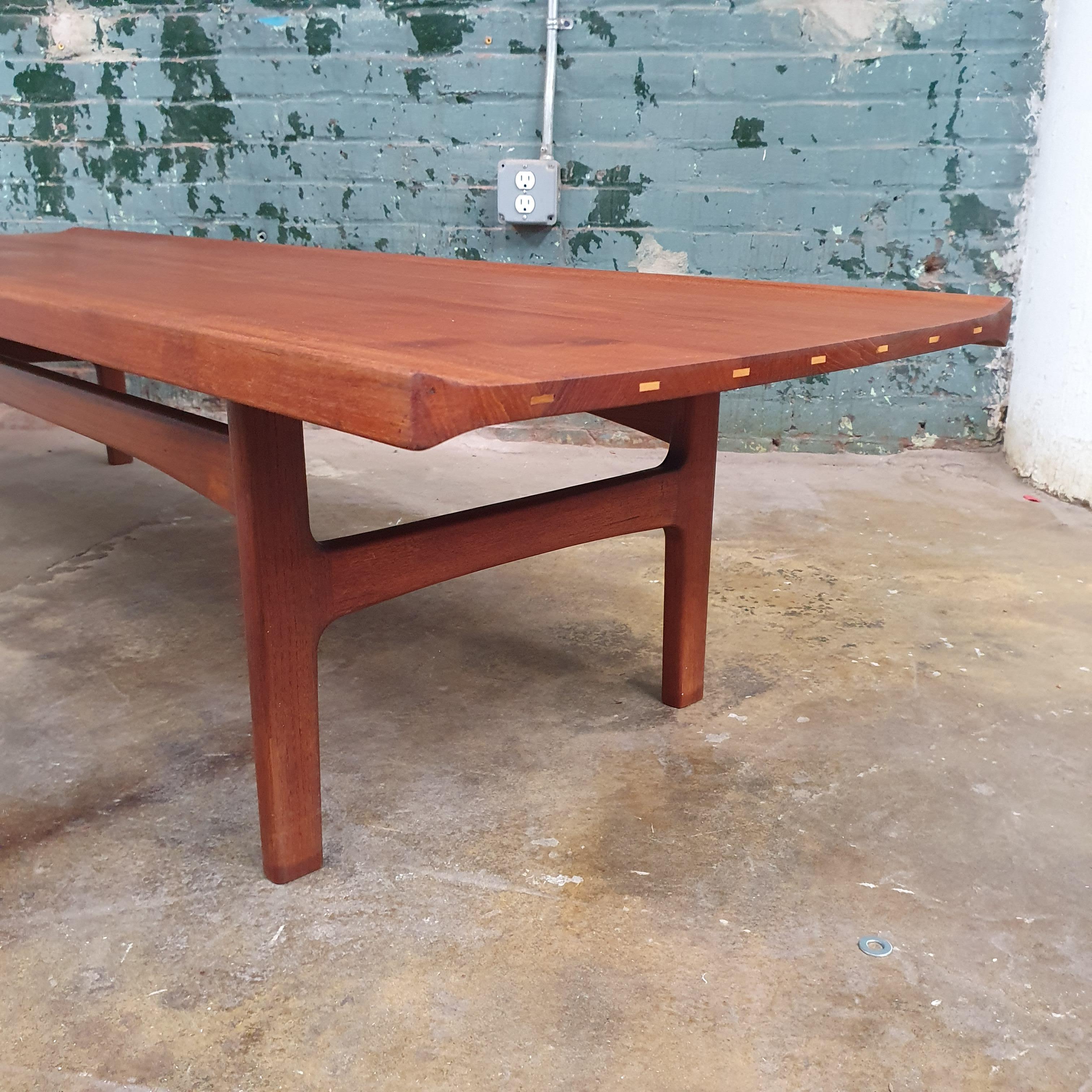 Vintage Solid teak coffee table by Tove and Edvard Kindt-Larsen for AB Seffle Mobelfabrik. Beautifully refinished with great lines. Sculpted sides with exposed joinery on the ends.

Measures: 72w x 22d x 15h.
