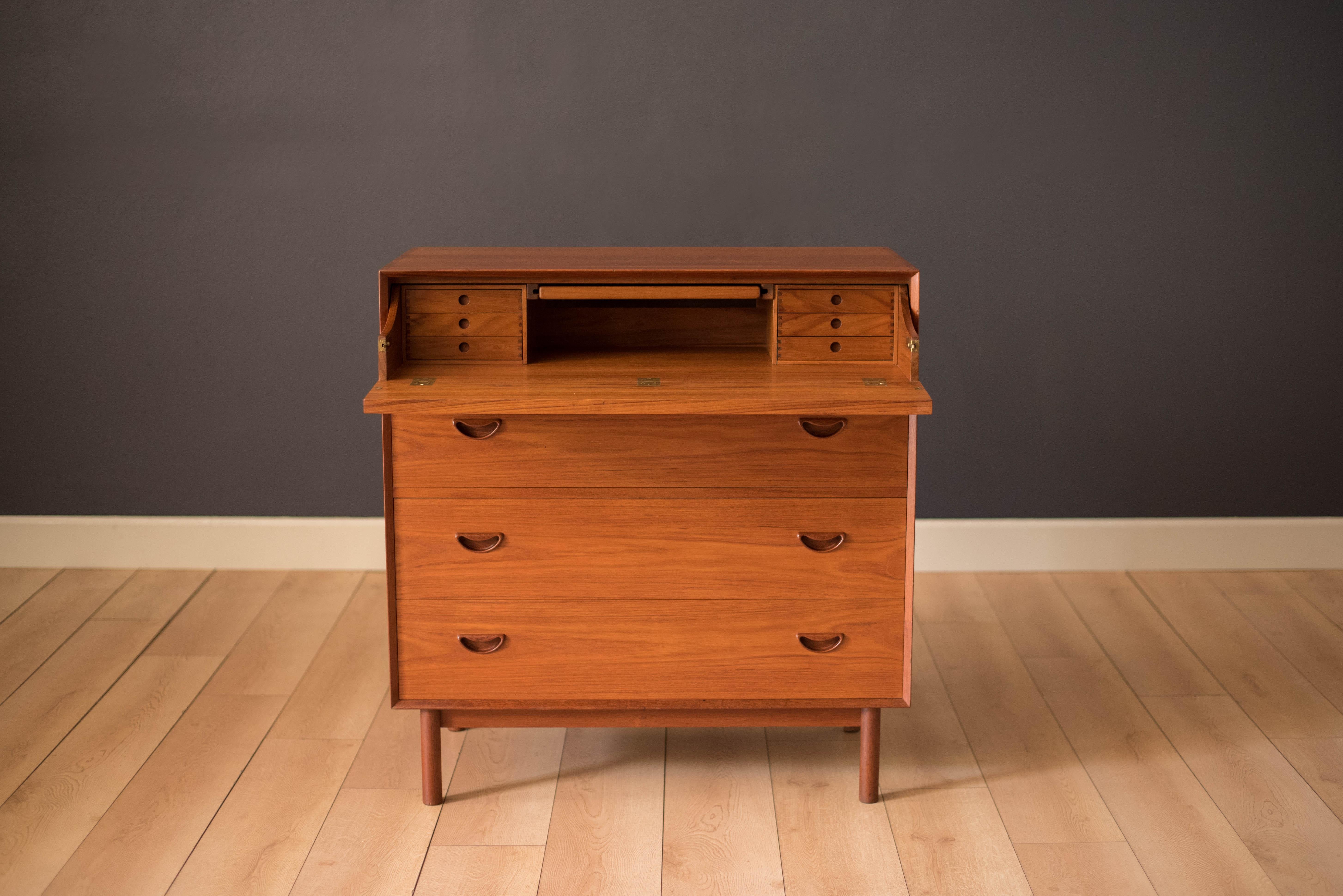 Mid-Century Modern teak dresser chest designed by Peter Hvidt and Orla Mølgaard-Nielsen for Søborg Møbler. This piece includes three storage drawers with signature sculpted handles. Features a hidden mirror vanity slide out desk that reveals six