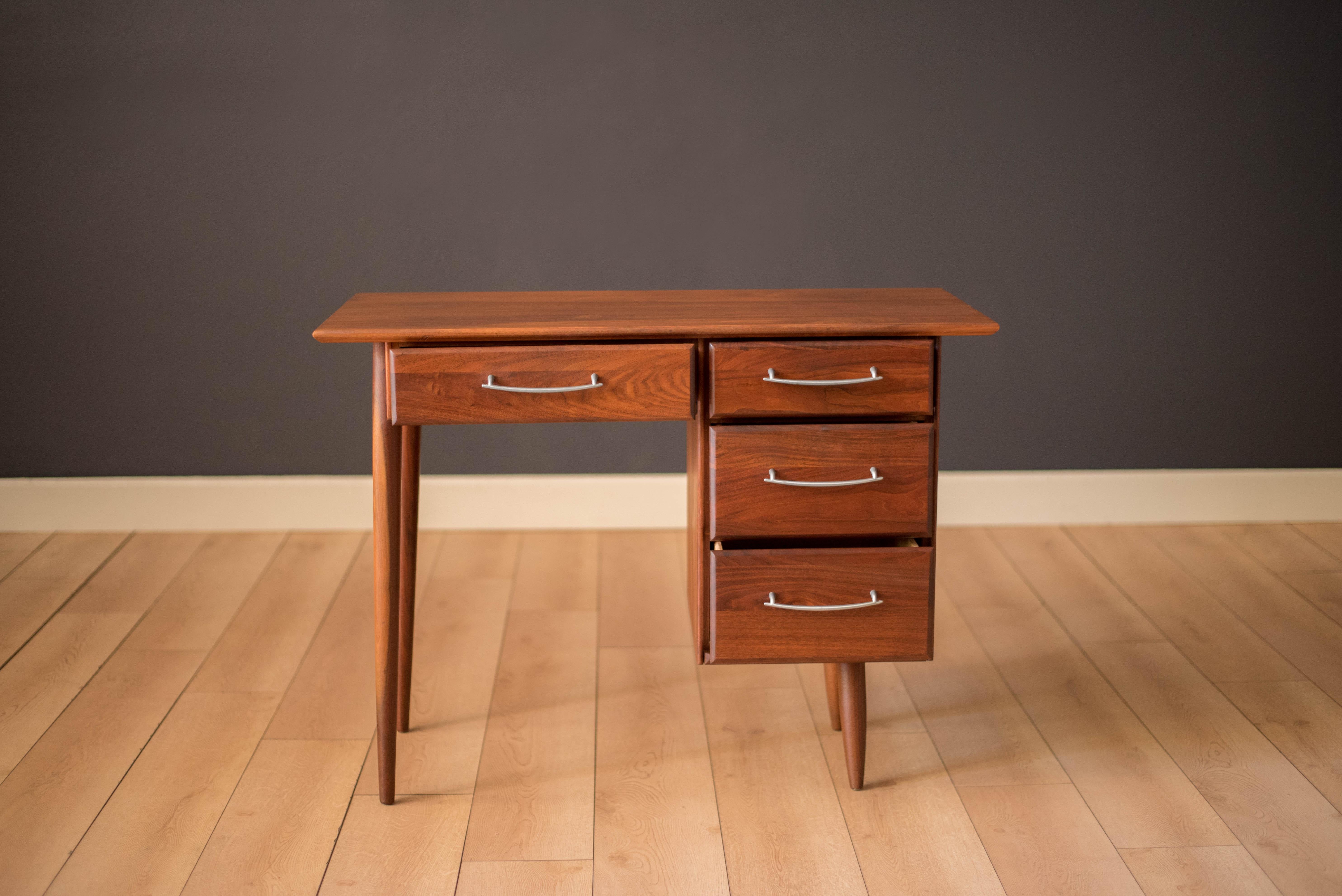 Mid century ACE-HI compact writing desk in solid planked walnut. This piece offers plenty of storage space complete with four drawers accessorized with pewter handles. 

Seat opening 17.5