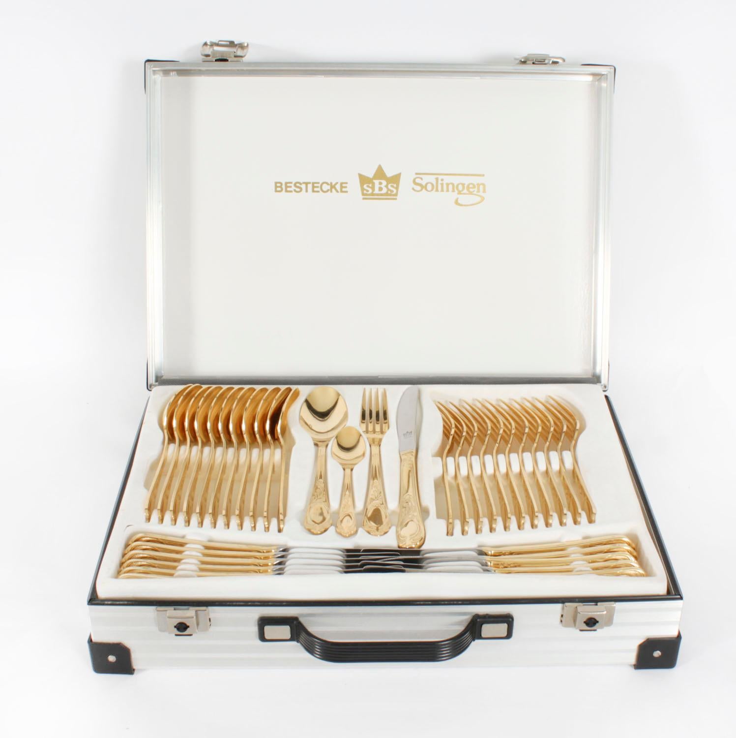 Il s'agit d'une magnifique cantine Vintage Solingen de 69 pièces de 12 couverts plaqués or 24kt, provenant d'Allemagne et datant de la fin du 20ème siècle.
 
L'ensemble est réalisé dans le charmant motif Golden Affection et est complet dans son étui