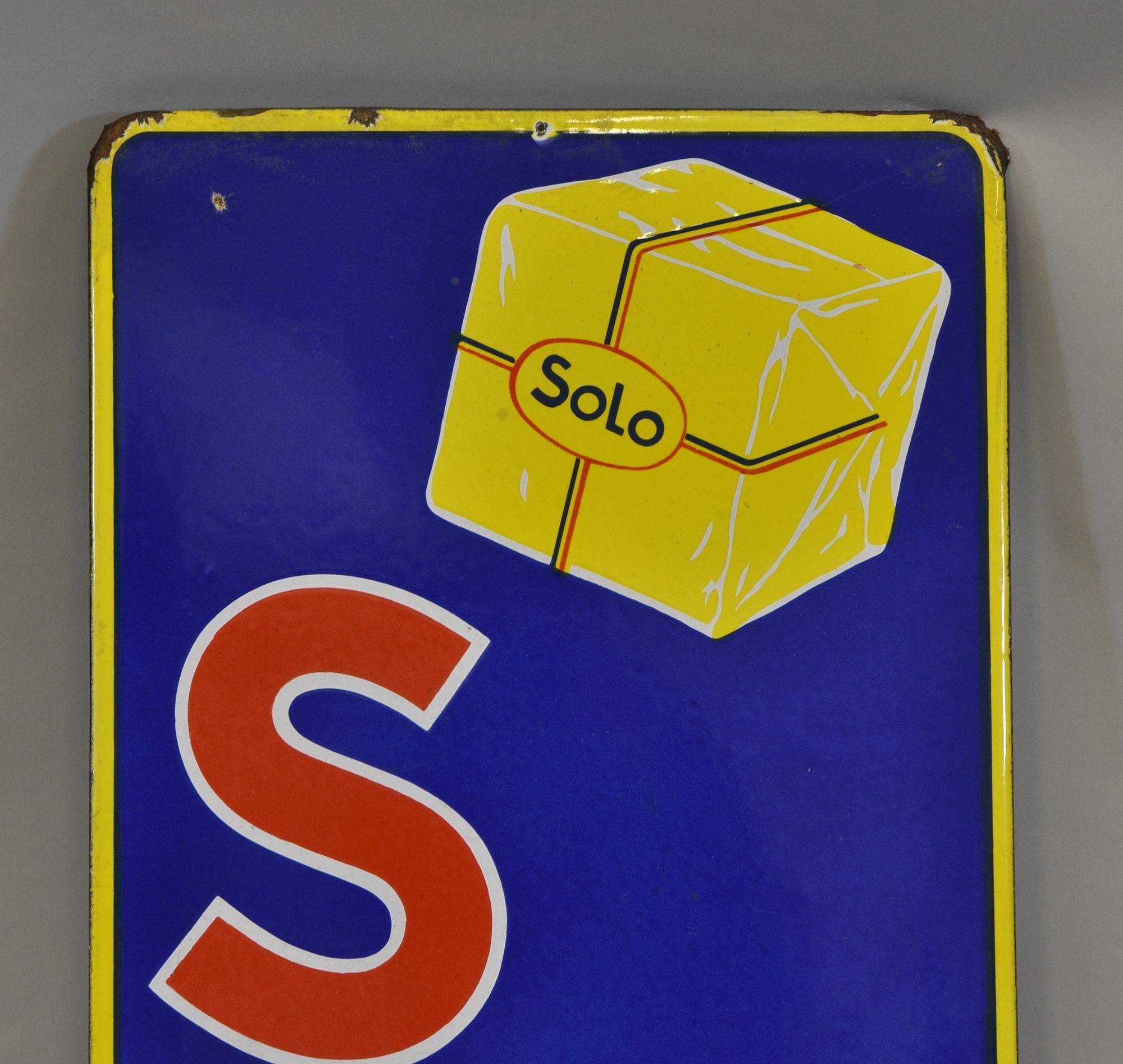 A wonderful bright vintage enamel sign advertising Solo margarine. Belgian - Circa 1940's.

The sign is in very good condition for its age, there is some wear to the edging in places, and some holes to the bottom right, please refer to the