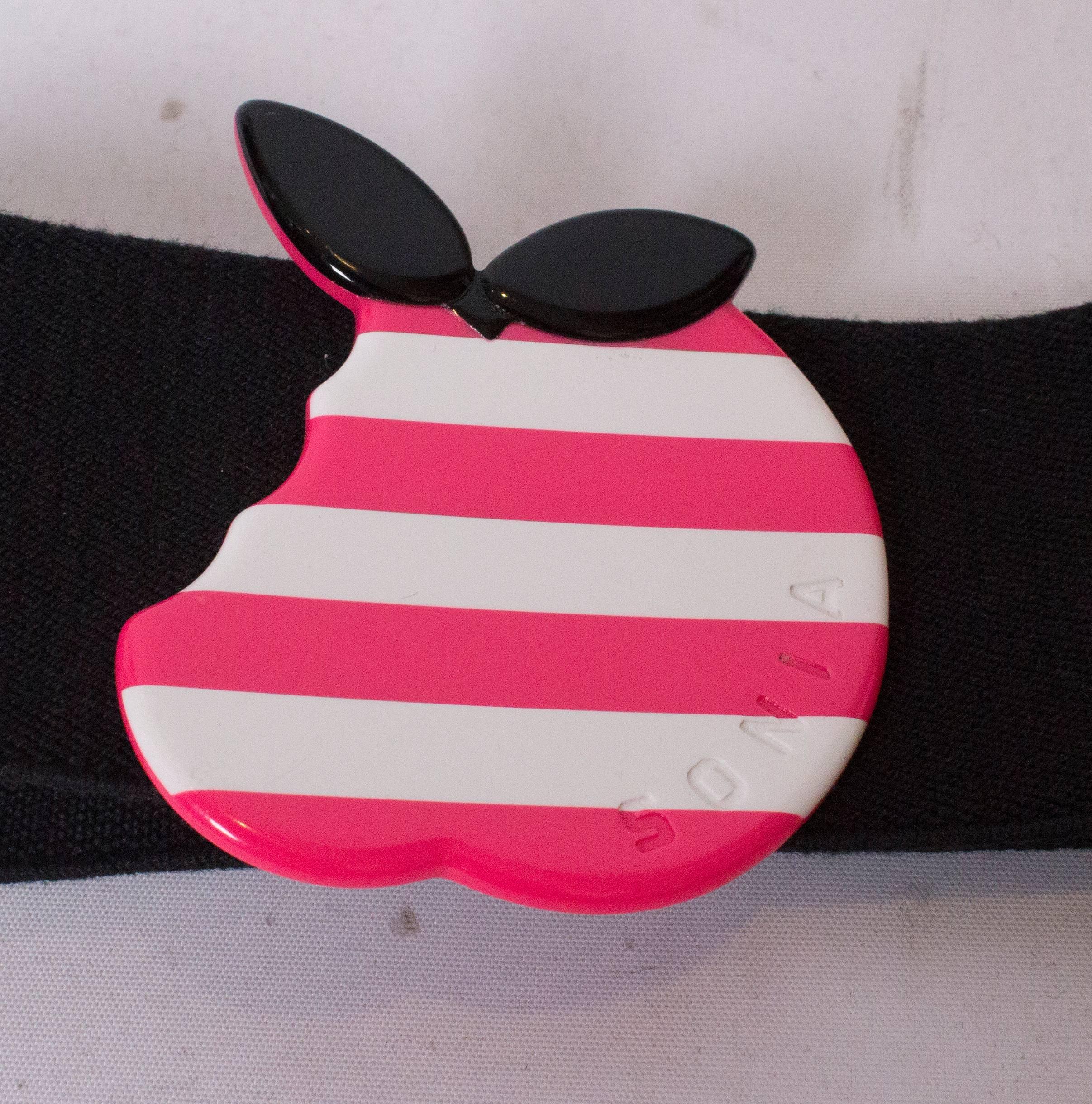 Une ceinture vintage amusante de Sonia Rykiel, ligne Sonia. La ceinture est en coton mélangé (52 % coton, 33 poly, 15 % élasthanne), de couleur noire, et se ferme par trois boutons-pression. Il est décoré d'une pomme rose et blanche avec des