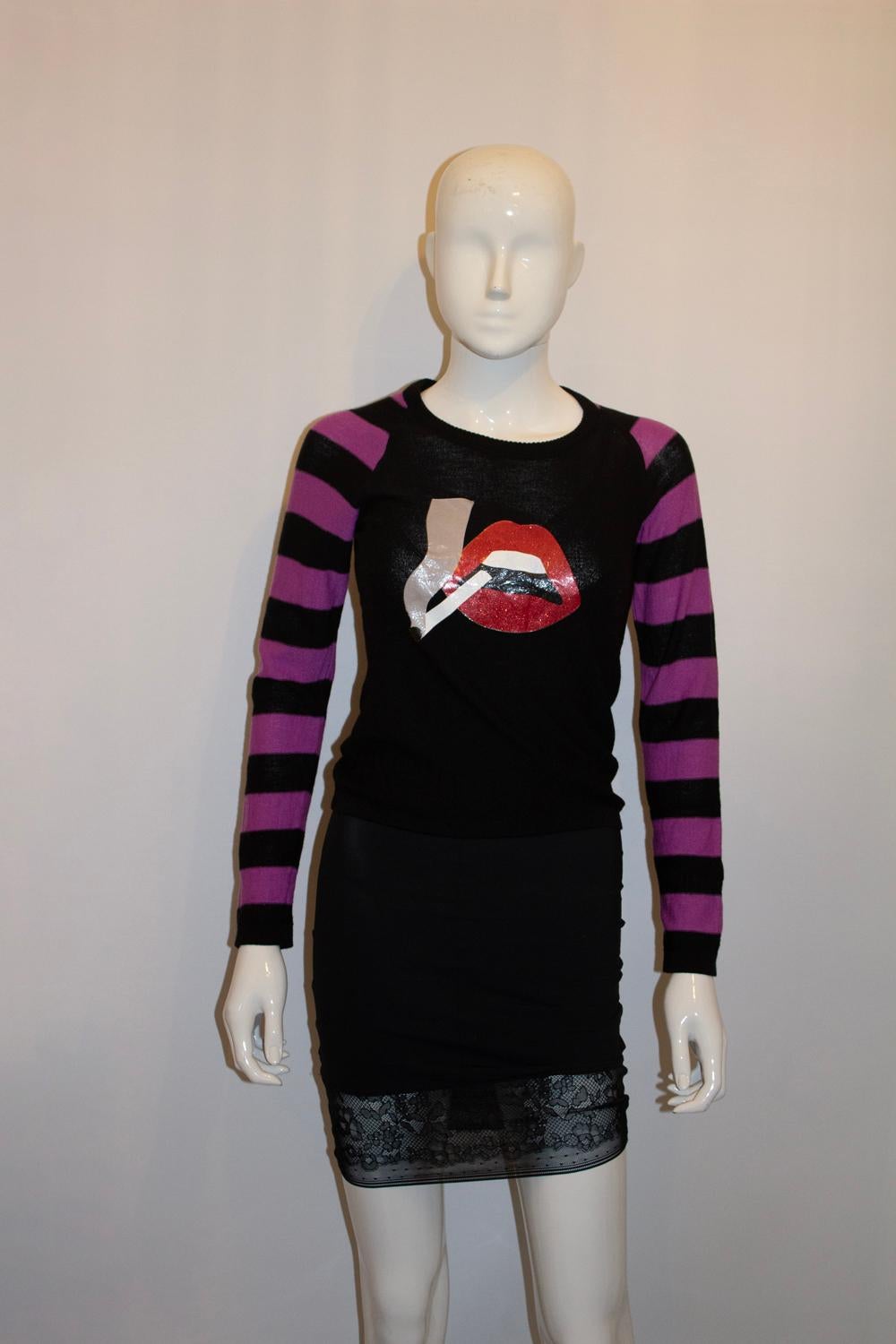 Ein etwas untypischer, aber wunderschöner ikonischer Pullover von Sonia Rykiel. Ähnlich wie das Design einer Rolling Stones LP, die Vorderseite des Pullovers als Mund mit einer Zigarette darin. Der Pullover hat lila und schwarze Streifen an den