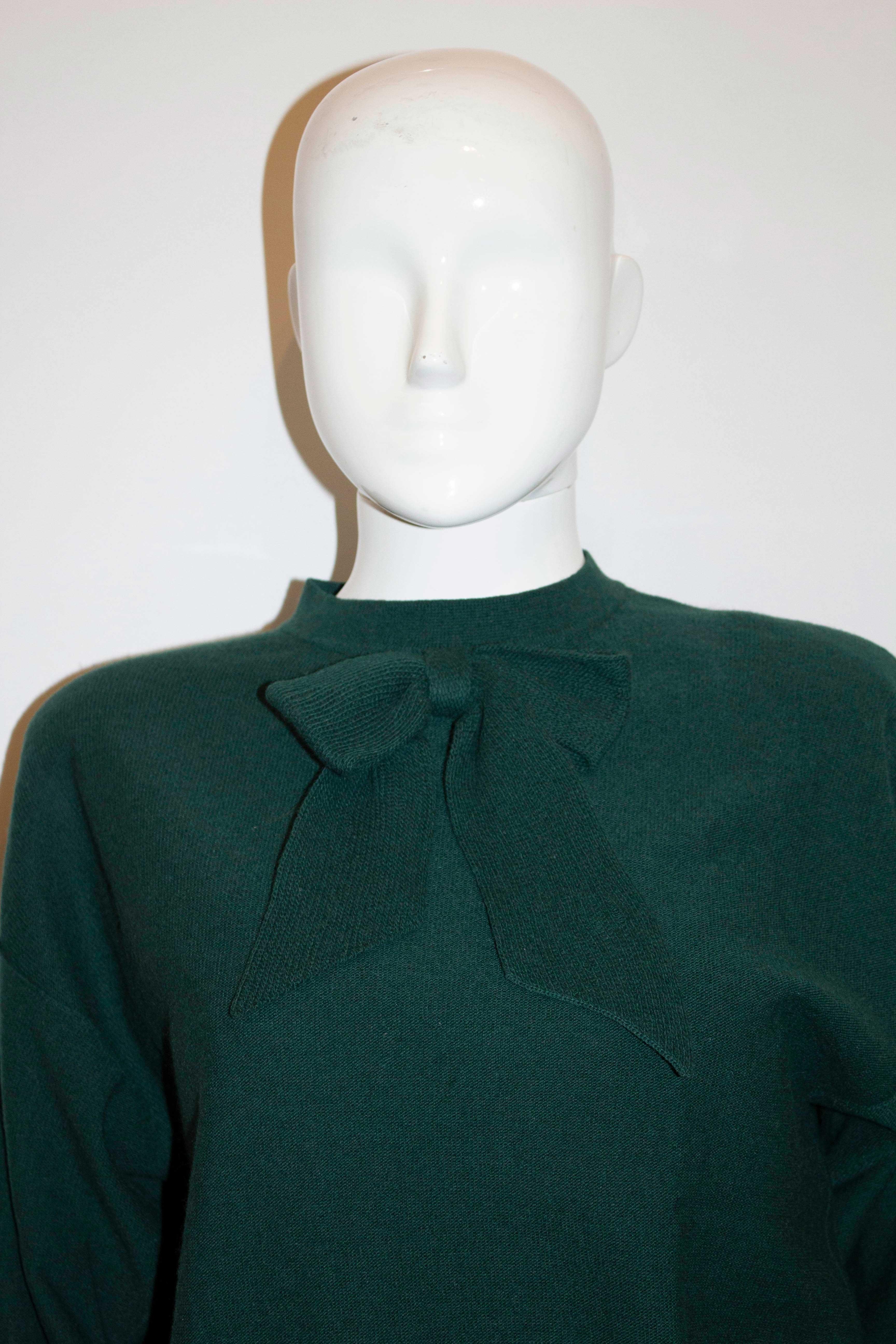 A great vintage green wool jumper by Sonia Rykiel mainline. The jumper is in a wonderful Christmas Tree green with a back popper opening, and a decorative knitted bow on the front. It has wide ribbing at the hem , ribbing on the cuffs and the