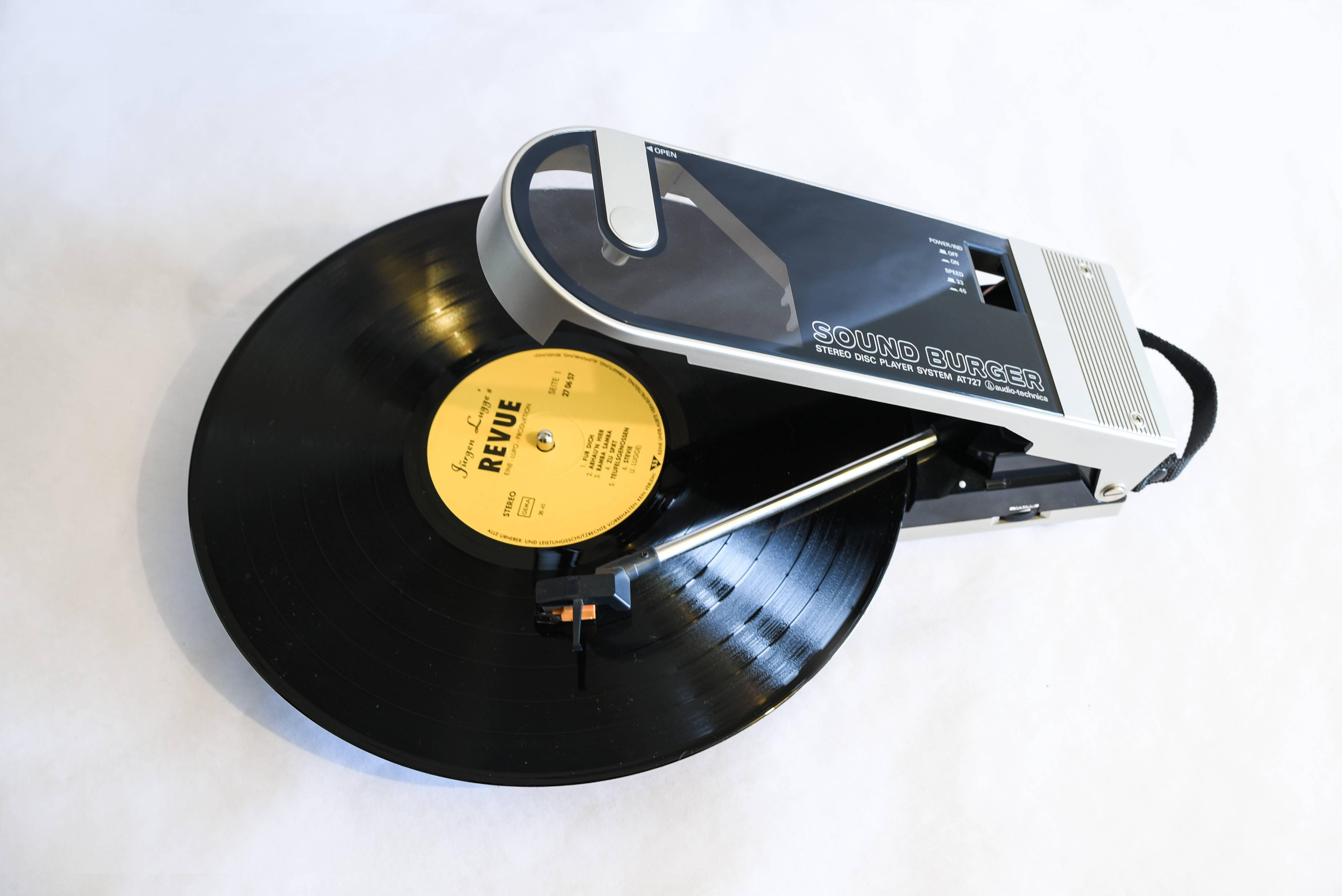 -Vintage Sound Burger AT 727 portable record player from Audio Technica.
NOS original packaging, the cartridge and belt were restored.
Designed to be played flat like a normal turntable, manual arm so skipping between tracks is fast. Platter: 90mm