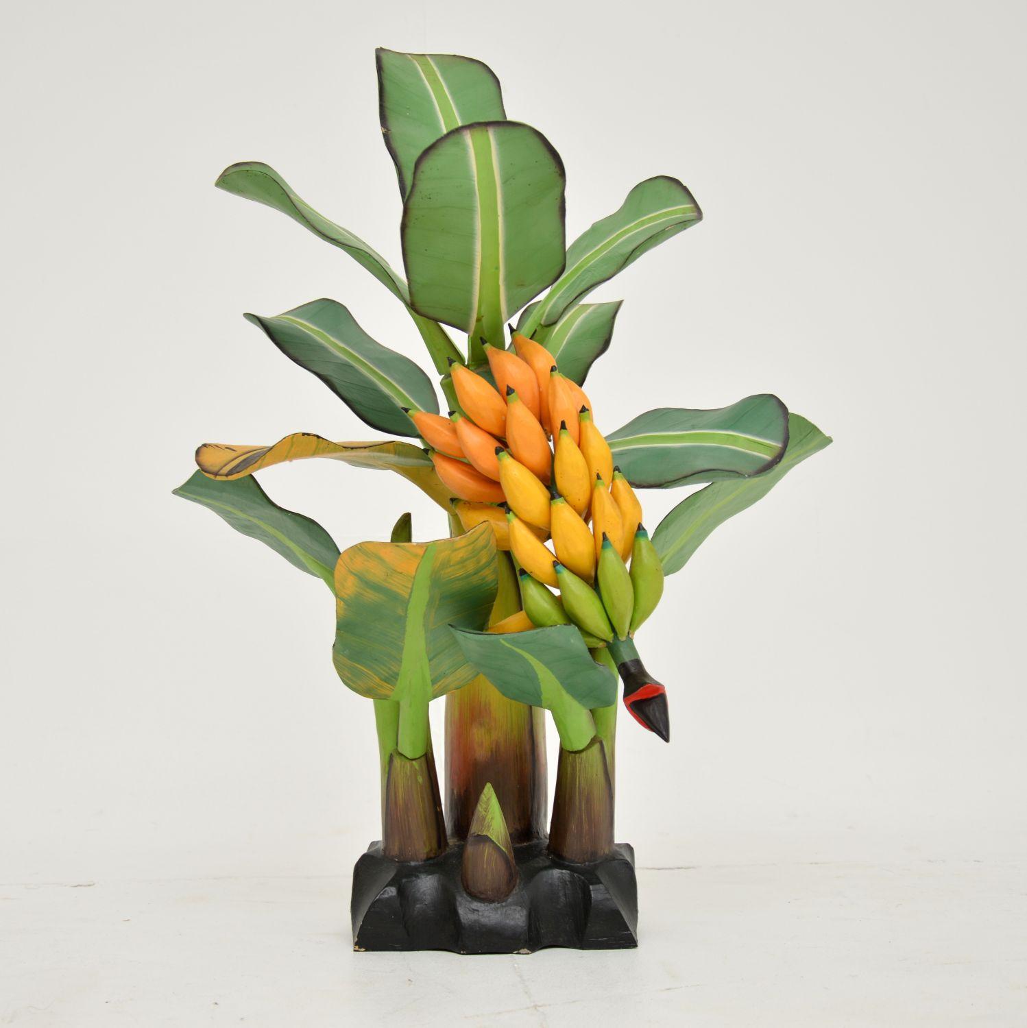 A beautiful and playful vintage carved wooden table top sculpture of a banana tree. This was obtained by a lady who got it while travelling South america in the 1970’s.

It is beautifully carved and painted, with stunning colours and intricate