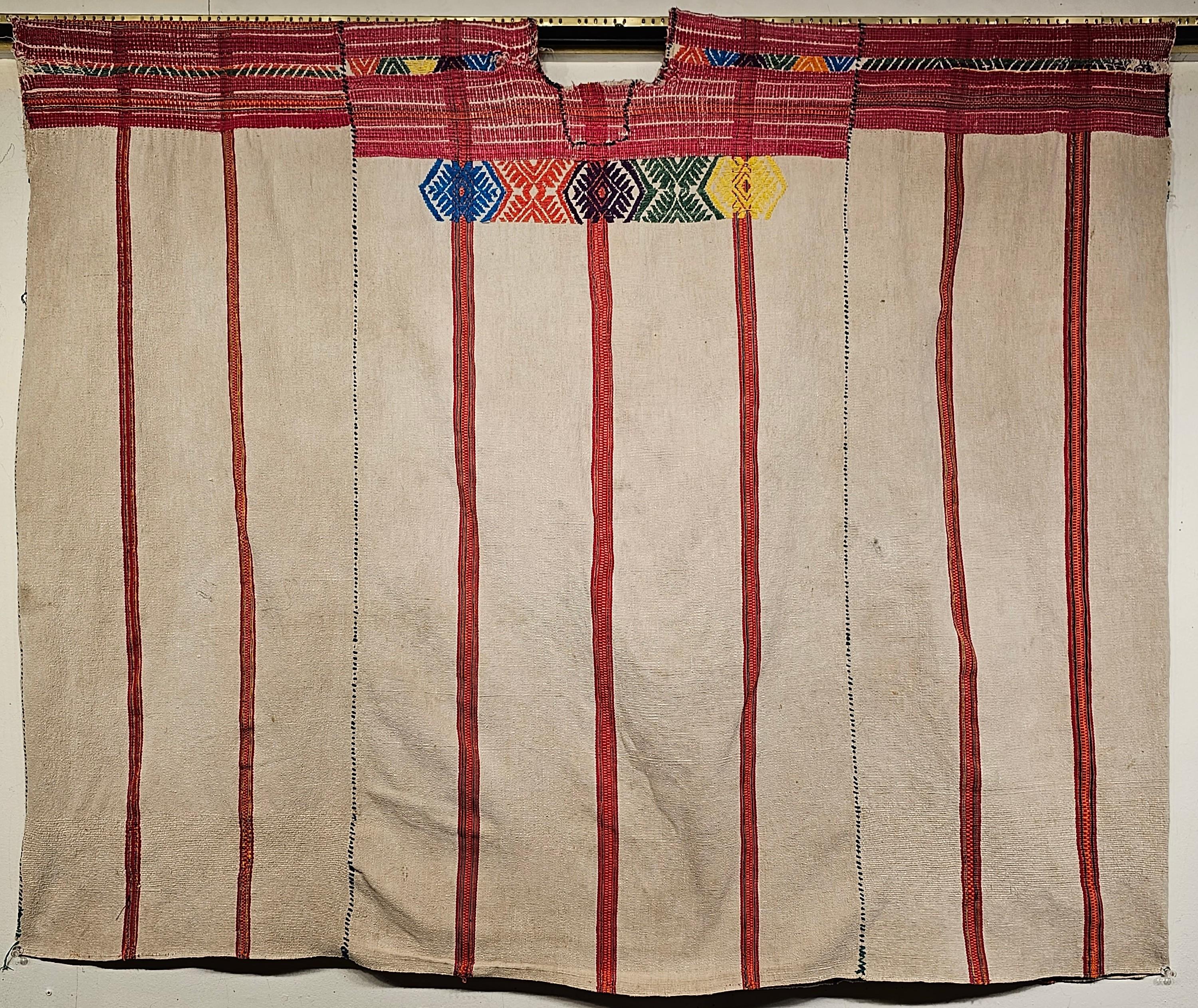 Handgewebter südamerikanischer Vintage-Textilstoff in Form eines Ponchos aus der Mitte des 20. Jahrhunderts.  Das Stück wird durch das Zusammennähen von drei einzeln gewebten Textilstücken zu einem Poncho geformt.  Der obere Teil des Textils ist mit