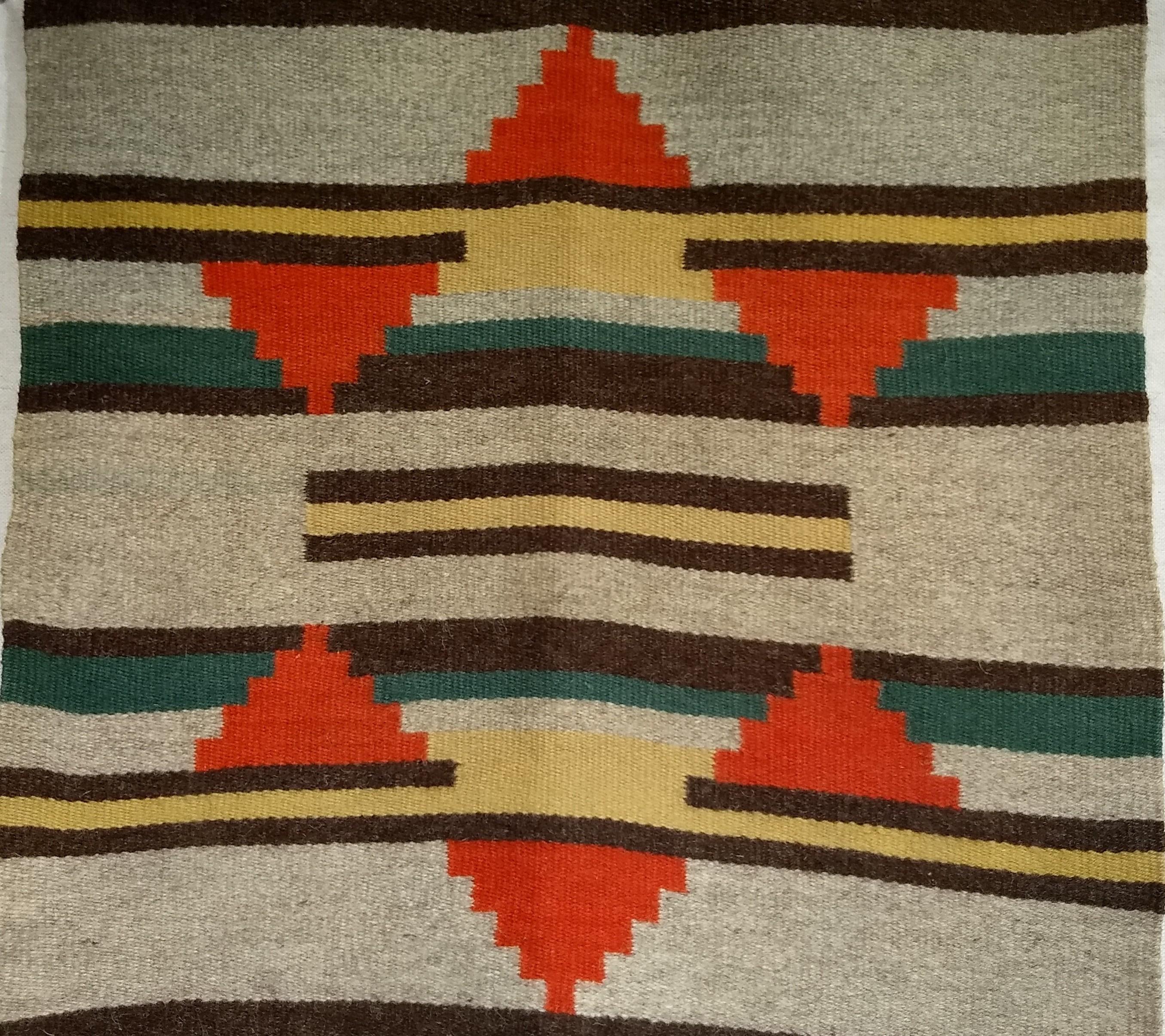 Vintage Native American Navajo rug is in a geometric band pattern in earth tone colors from the mid the 1900s.   The rug is a very fine weave and extremely lushes and soft wool.  The rug has a geometric design in brilliant colors of wheat, brown,