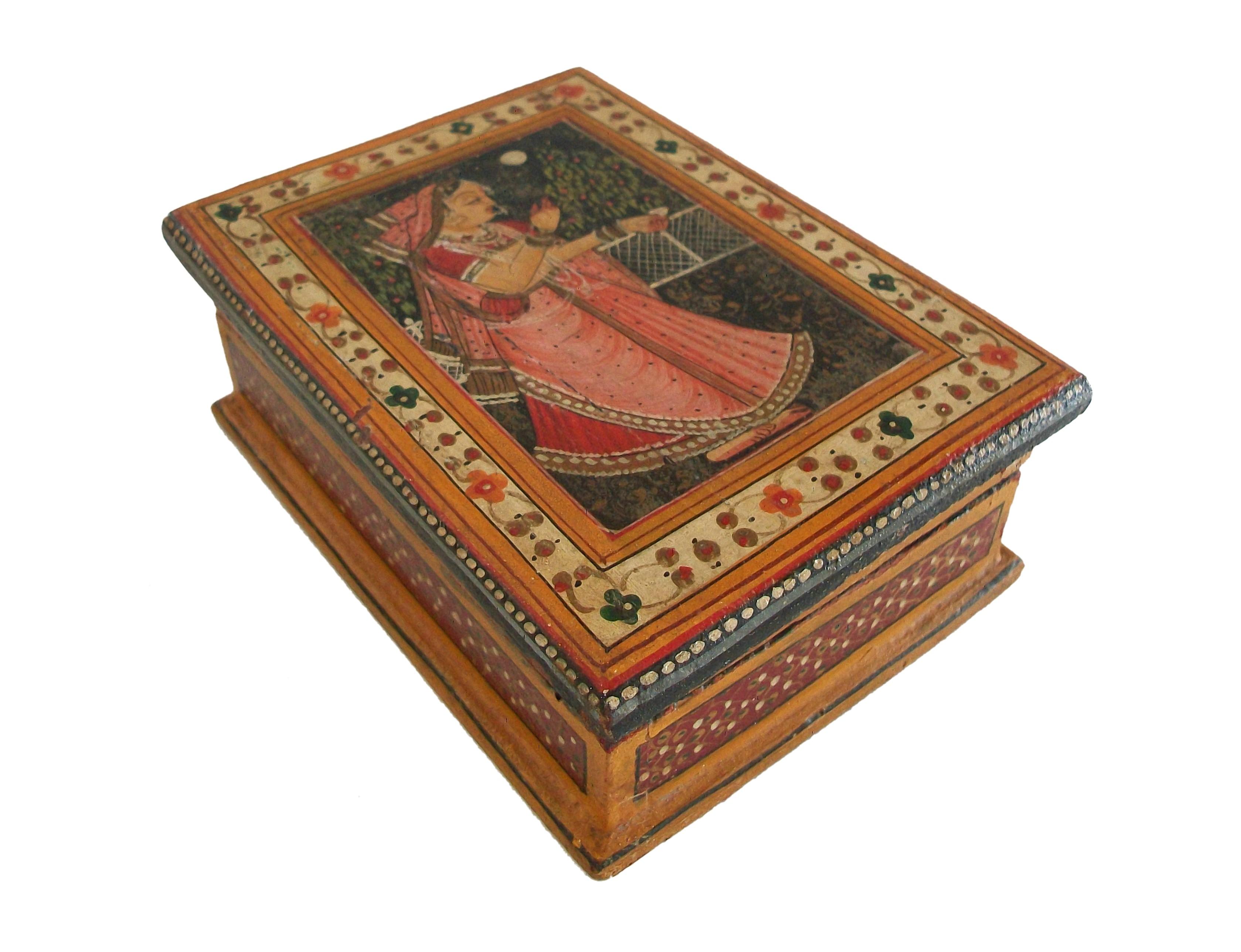 Vintage South Asian hand painted wooden box with removeable lid - featuring a full length portrait of an Indian woman in a pink sari to the lid of the box surrounded by a floral border - intricately patterned / painted sides - original paper label