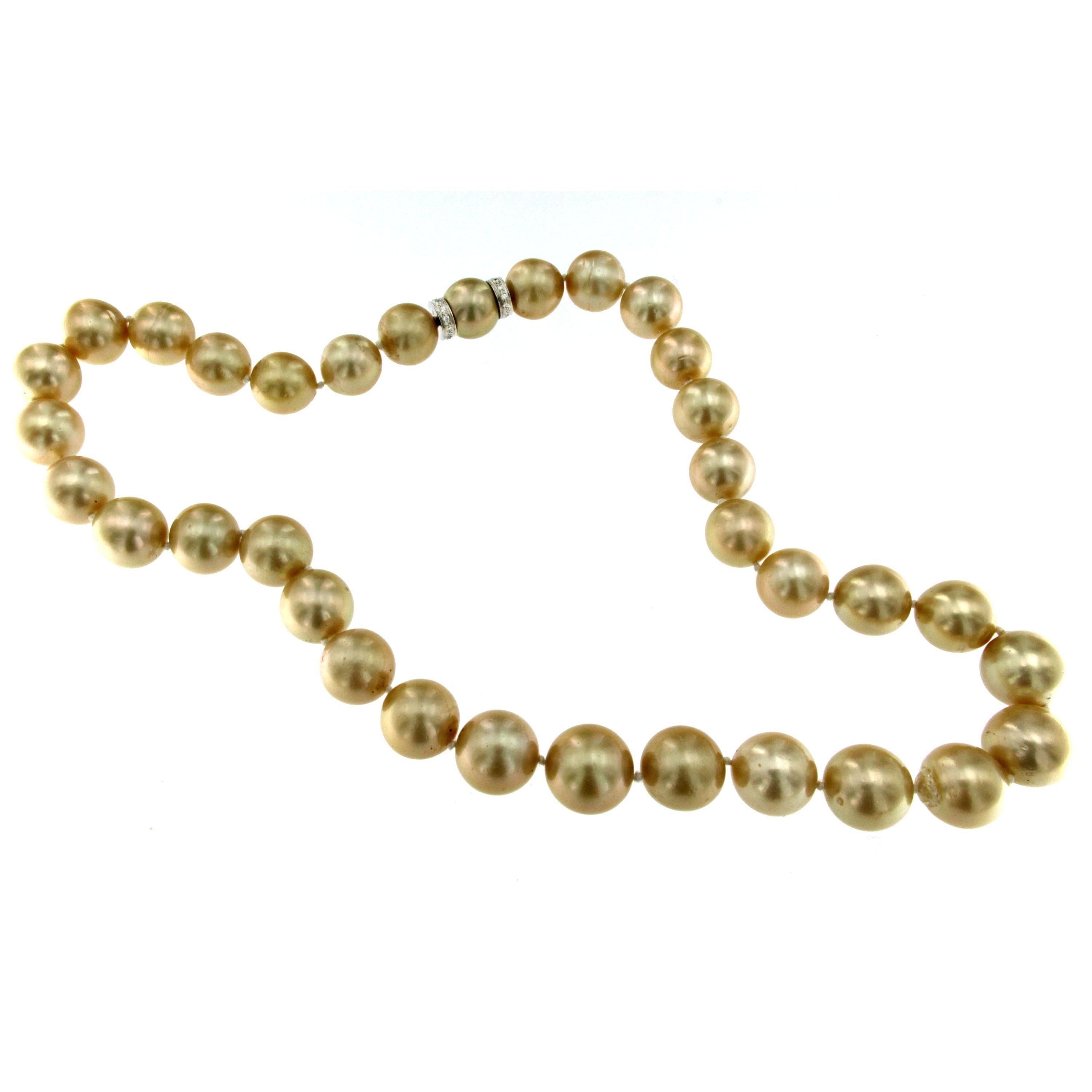 One of the most Beautiful and large Golden South Sea pearl necklace we've ever had for sale, this strand includes 12-14 millimeter pearls strung on a knotted silk thread and fasten with a gorgeous pearl diamond clasp. This strand is an heirloom