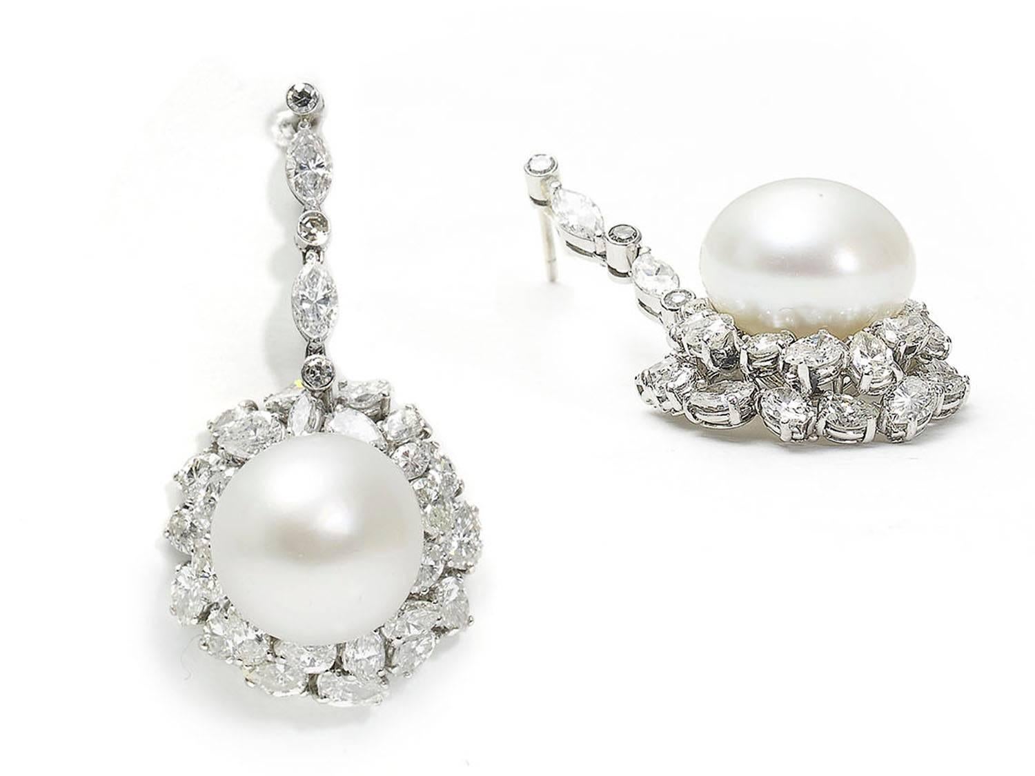 A pair of South Sea bouton pearl and diamond drop earrings, set with approximately 6.00ct of pear shape, marquise, round brilliant and eight-cut diamonds, mounted in white gold, with posts and butterfly fittings, circa 1965.