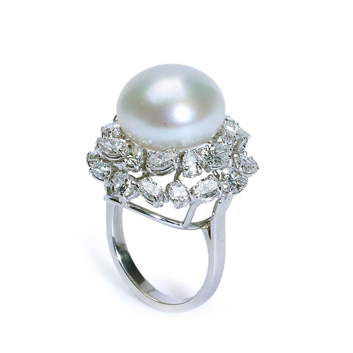A South Sea pearl and diamond ring, with a large bouton pearl, surrounded by a diamond cluster, set with  pear shape diamonds, in assorted sizes, with an estimated the total diamond weight of 3.42 carats, in our opinion the colour range is G to K