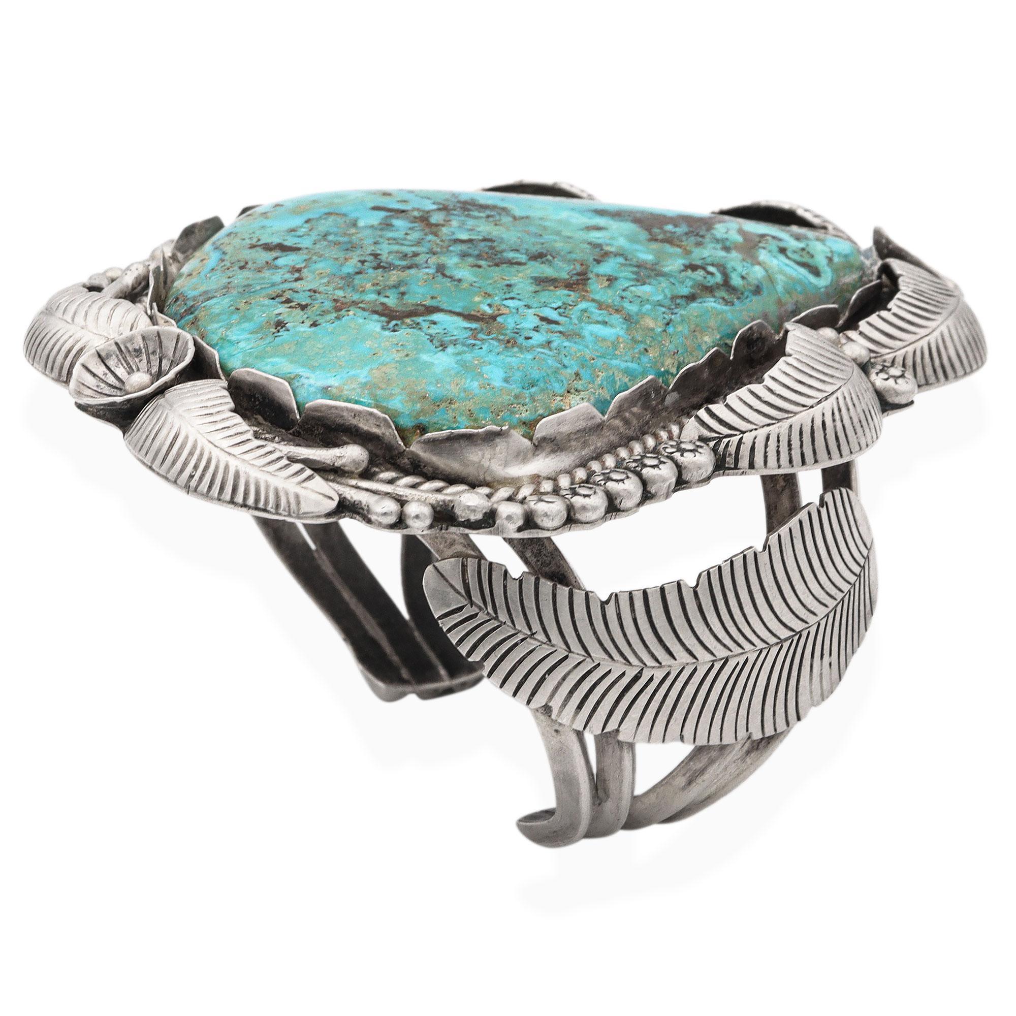 Ce bracelet manchette vintage du sud-ouest amérindien est une célébration audacieuse de l'artisanat traditionnel et de la beauté naturelle. Fabriquée à la main en argent sterling, la pièce s'articule autour d'une impressionnante turquoise de forme
