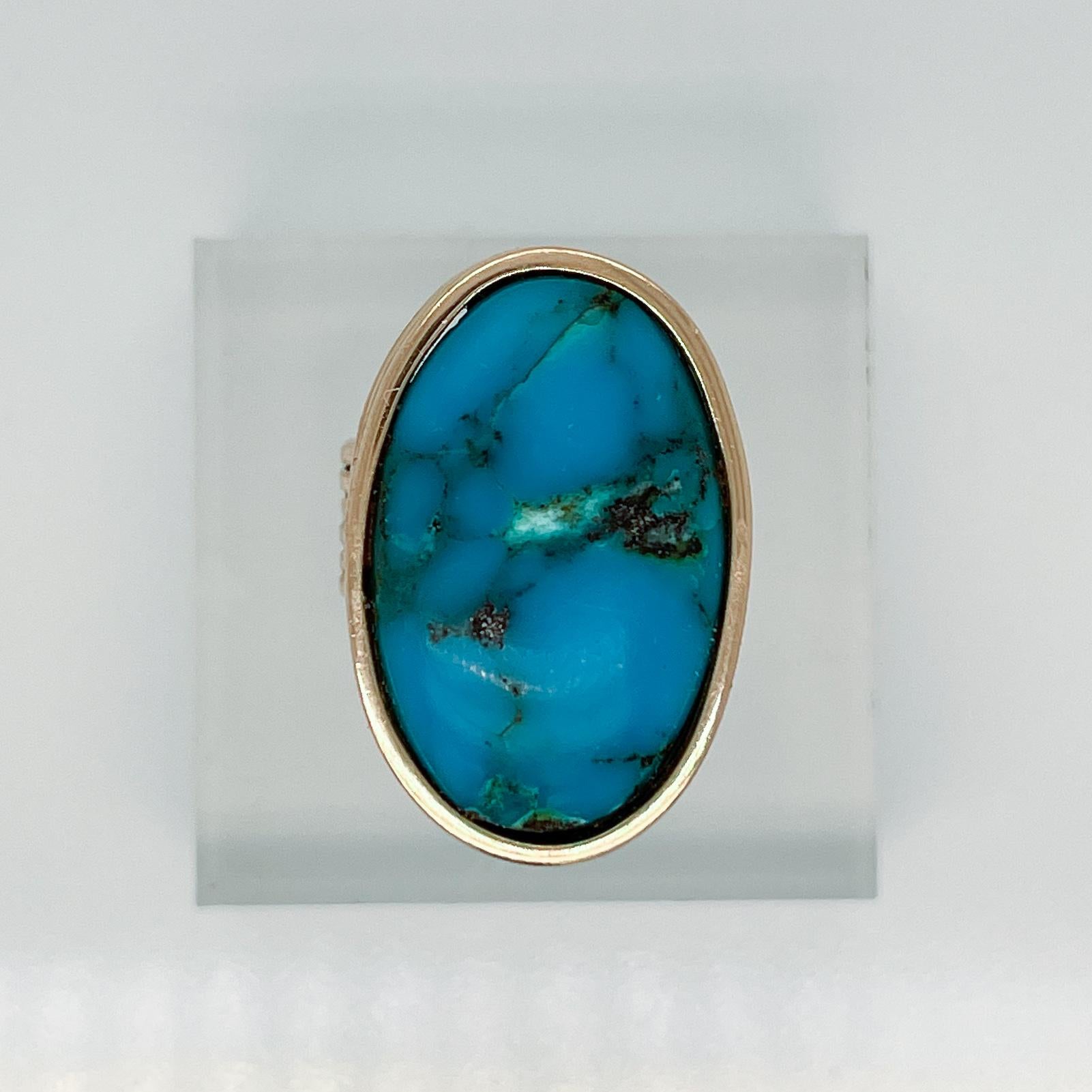 A fine bench made signet type ring.

In 14k gold.

With an oval turquoise cabochon set in a deep bezel setting surmounting a ribbed band.

Simply a wonderful Southwestern ring!

Date:
20th Century

Overall Condition:
It is in overall good,