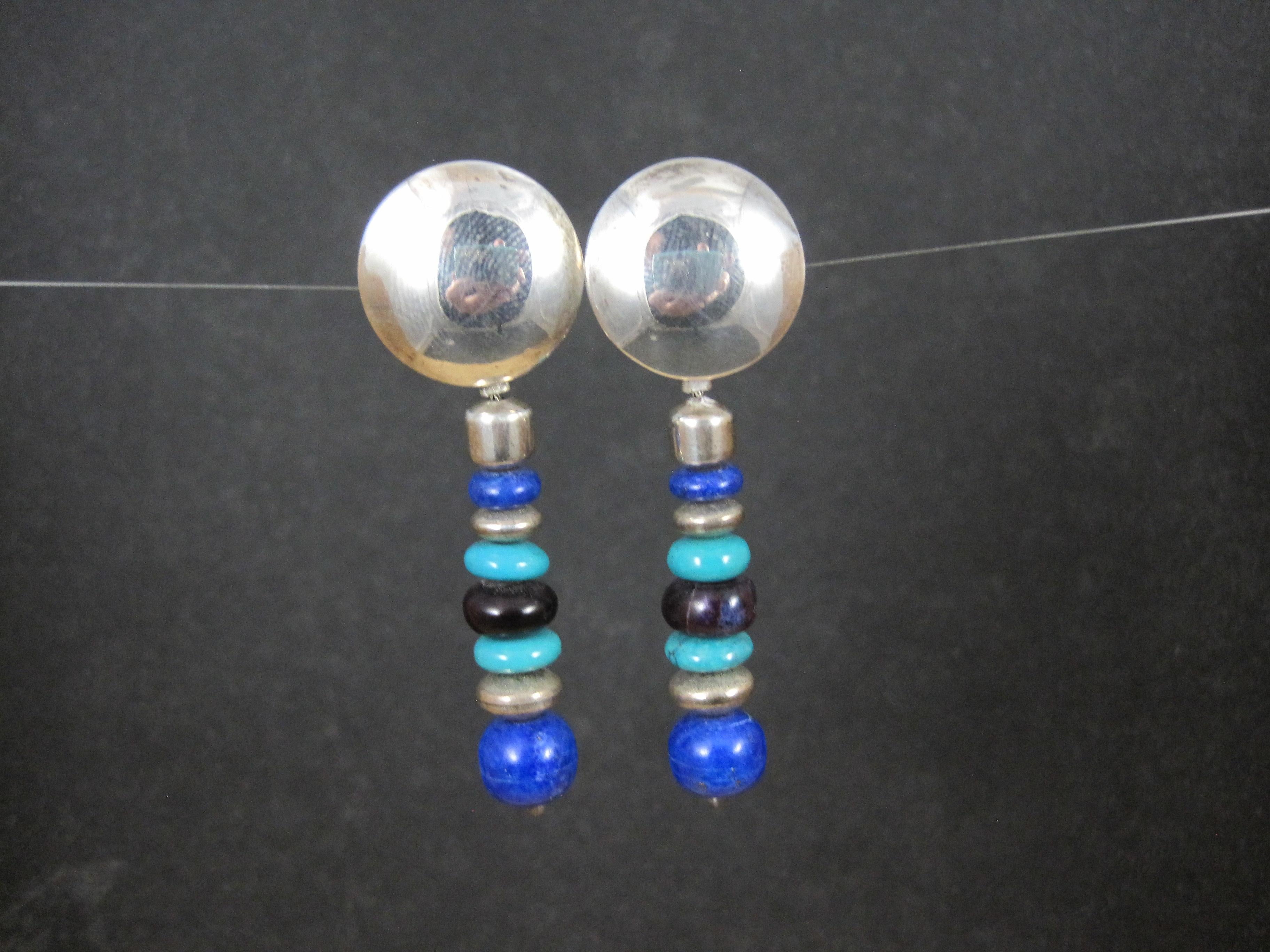 These gorgeous native american earrings are comprised of sterling silver, bright blue lapis lazuli, turquoise and charoite gemstones.

These earrings measure 3/4 of an inch at the post and 2 1/4 inches long.

Marks: None

Condition: Excellent with