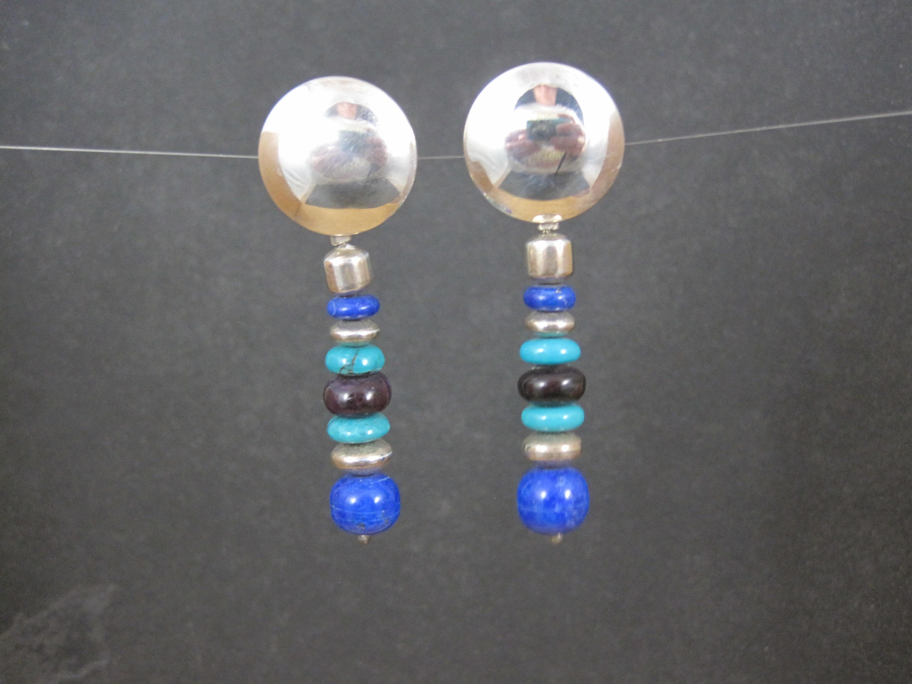 These gorgeous native american earrings are comprised of sterling silver, bright blue lapis lazuli, turquoise and charoite gemstones.

These earrings measure 3/4 of an inch at the post and 2 1/4 inches long.

Marks: None

Condition: Excellent - old