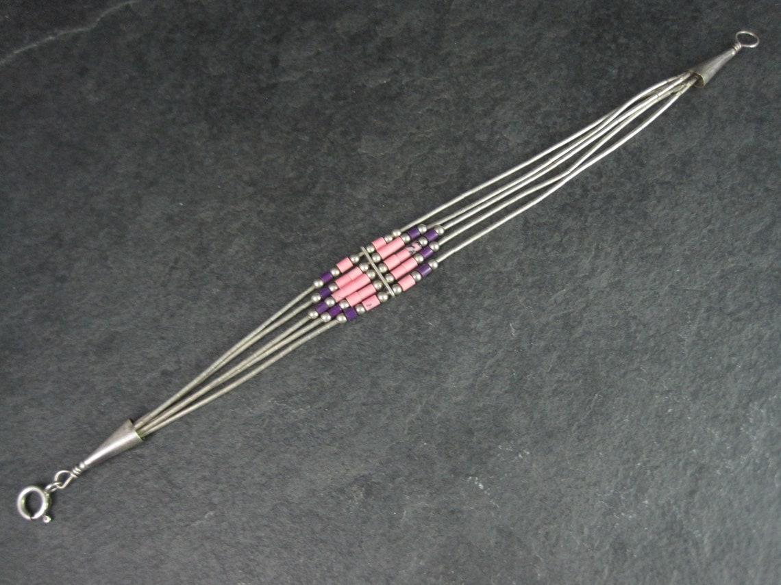 Dieses schöne Armband aus dem Südwesten besteht aus Sterlingsilber mit Sugilith- und Rhodochrosit-Perlen.

Abmessungen: 1/2 Zoll an seiner breitesten Stelle, 7 tragbare Zoll

Zustand: Ausgezeichnet