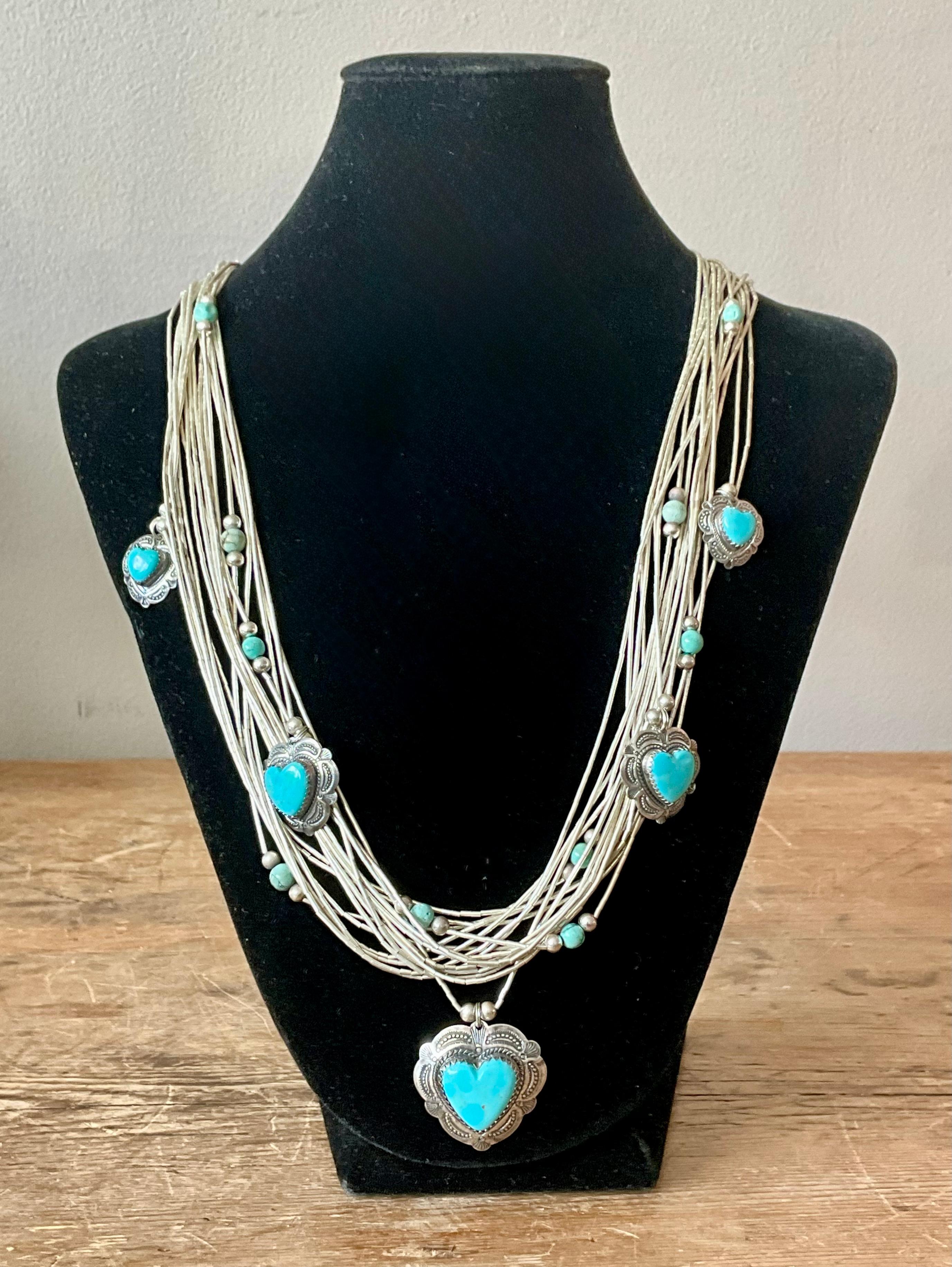 Ce collier multibrins vintage du Sud-Ouest est un hommage stupéfiant à l'art traditionnel et à la beauté naturelle. Composé de plusieurs rangs de perles turquoise vibrantes, le collier met en valeur deux pendentifs en forme de cœur turquoise