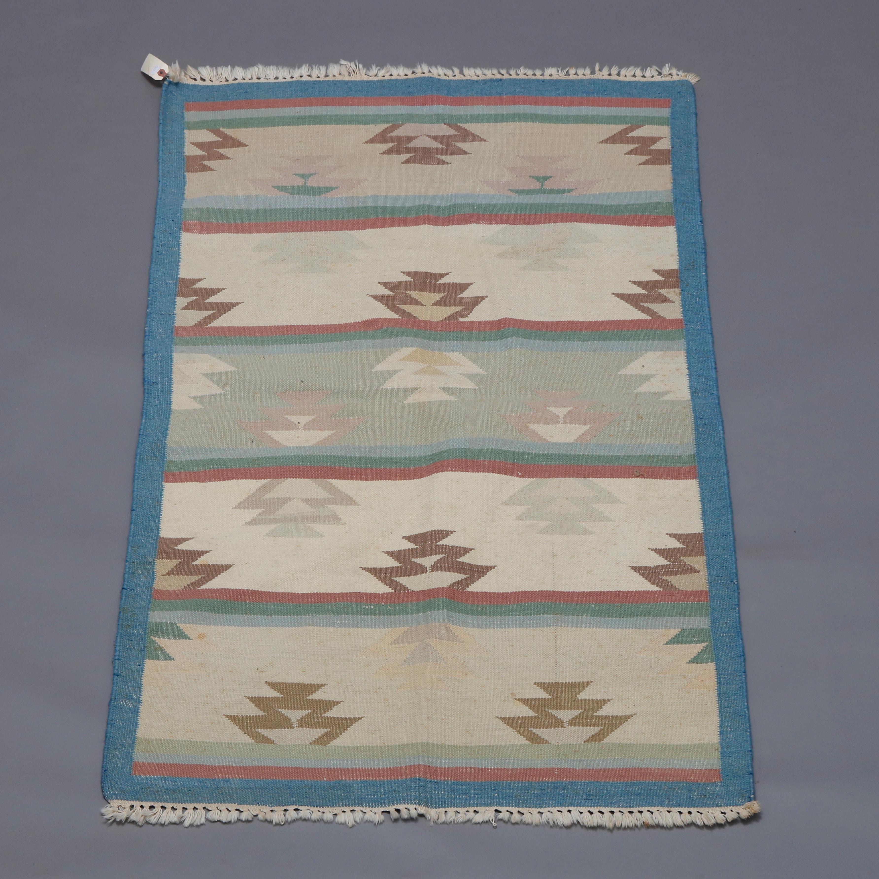 A vintage Southwestern Navajo style area rug offers flat-weave construction with a repeating stylized flame pattern in pastel palette, circa 1950.


Measures: 61