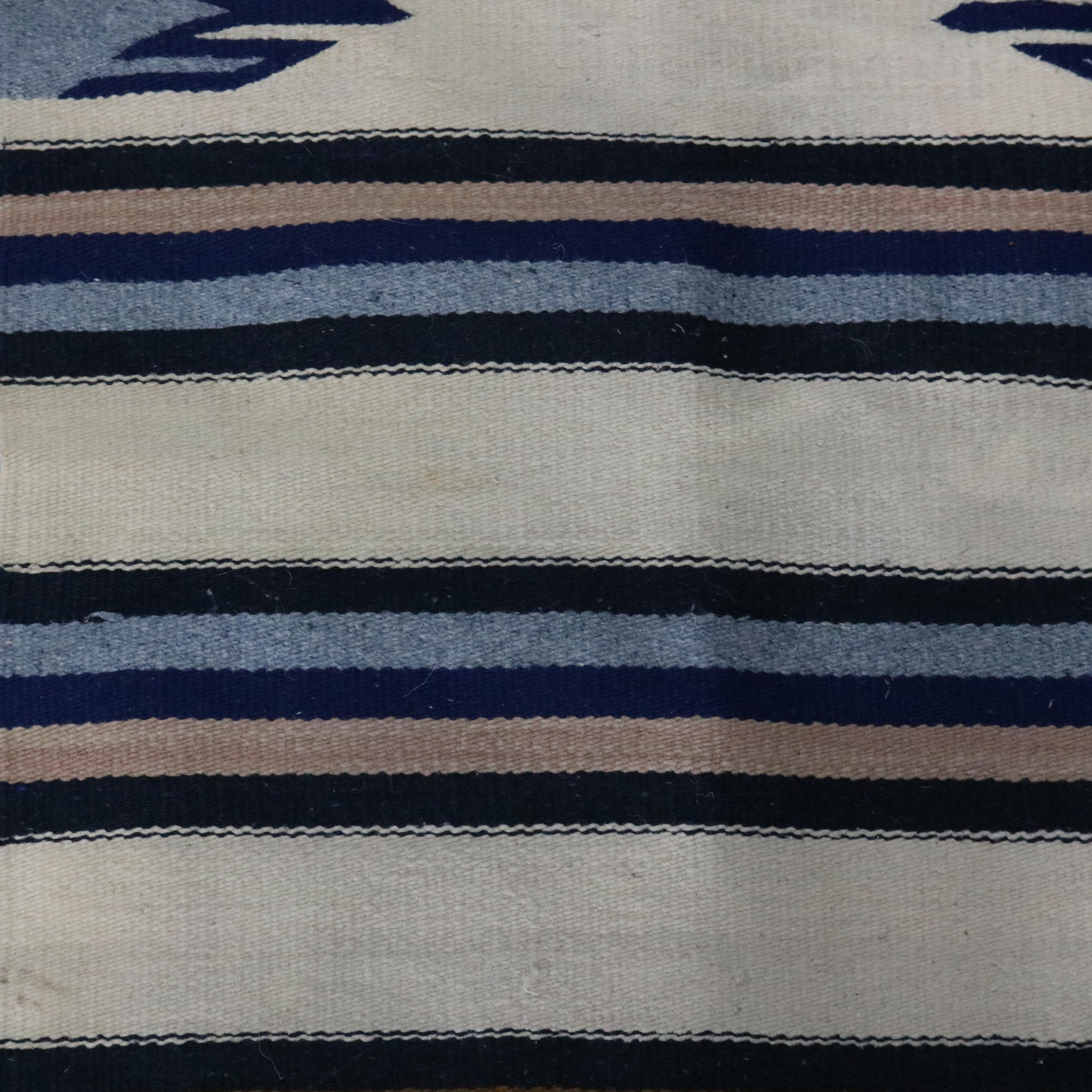 A vintage Southwestern rug in the manner of Navajo offers wool construction with striped design having stylized feather accents, circa 1930

Measures: 58.5