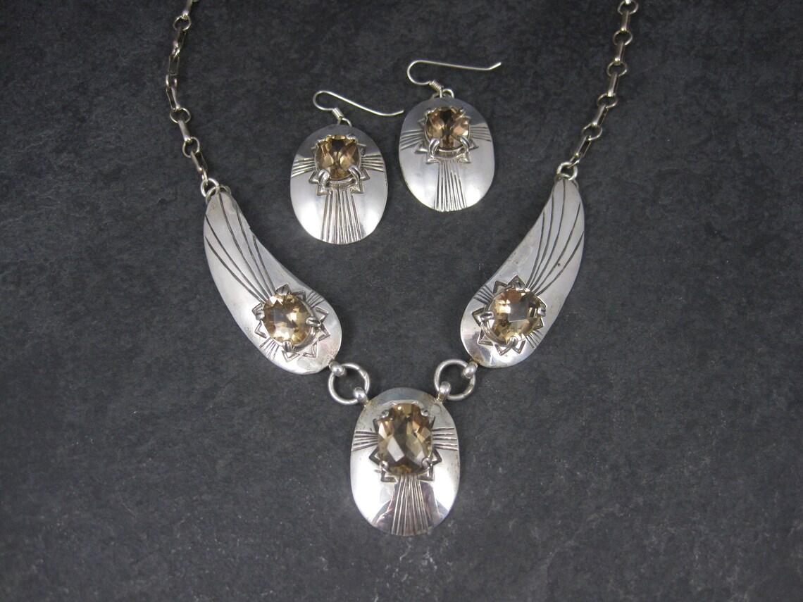 This gorgeous Southwestern jewelry set is sterling silver with natural citrine stones.

Necklace:
18 1/2 inches from end to end - 10 inches from clasp to tip of the focal when clasped.
3 oval faceted citrines measuring 9x11mm each with an estimated
