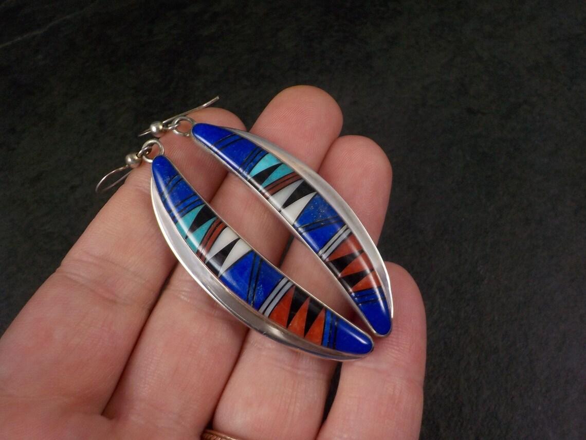 These gorgeous earrings are sterling silver.
They feature inlay in lapis, jet, turquoise, mother of pearl and coral.

Measurements: 7/16 of an inch at their widest and 2 3/4 inches long from the top of the earwire.
Weight: 15.7 grams

Marks: