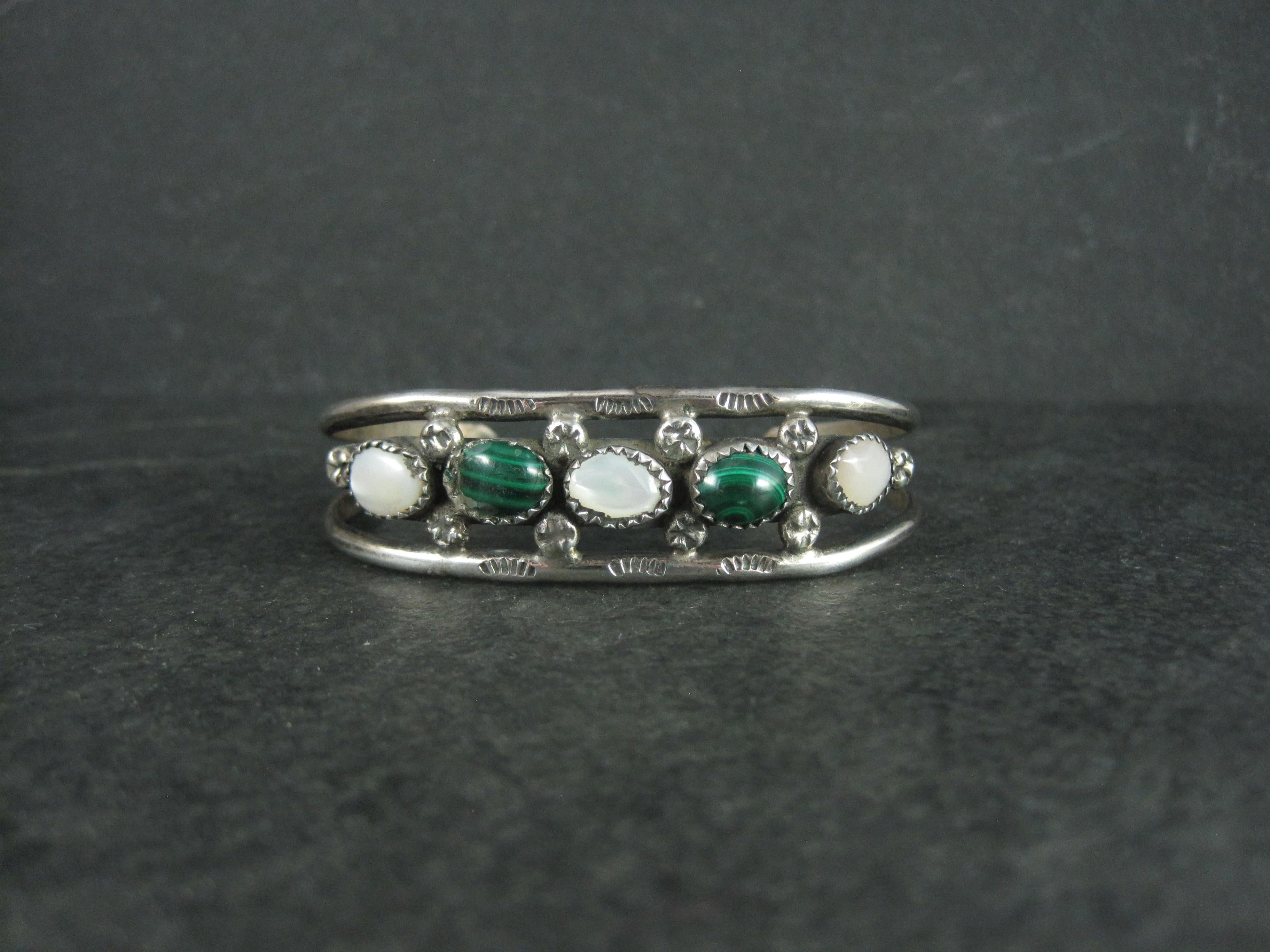 Este precioso brazalete del suroeste es de plata de ley con piedras alternas de malaquita y nácar.

Esta pulsera mide 11/16 de pulgada de ancho.
Tiene una circunferencia interior de 15 cm, incluido el hueco de 2,5 cm.
Peso: 14.5 gramos

Marcas: