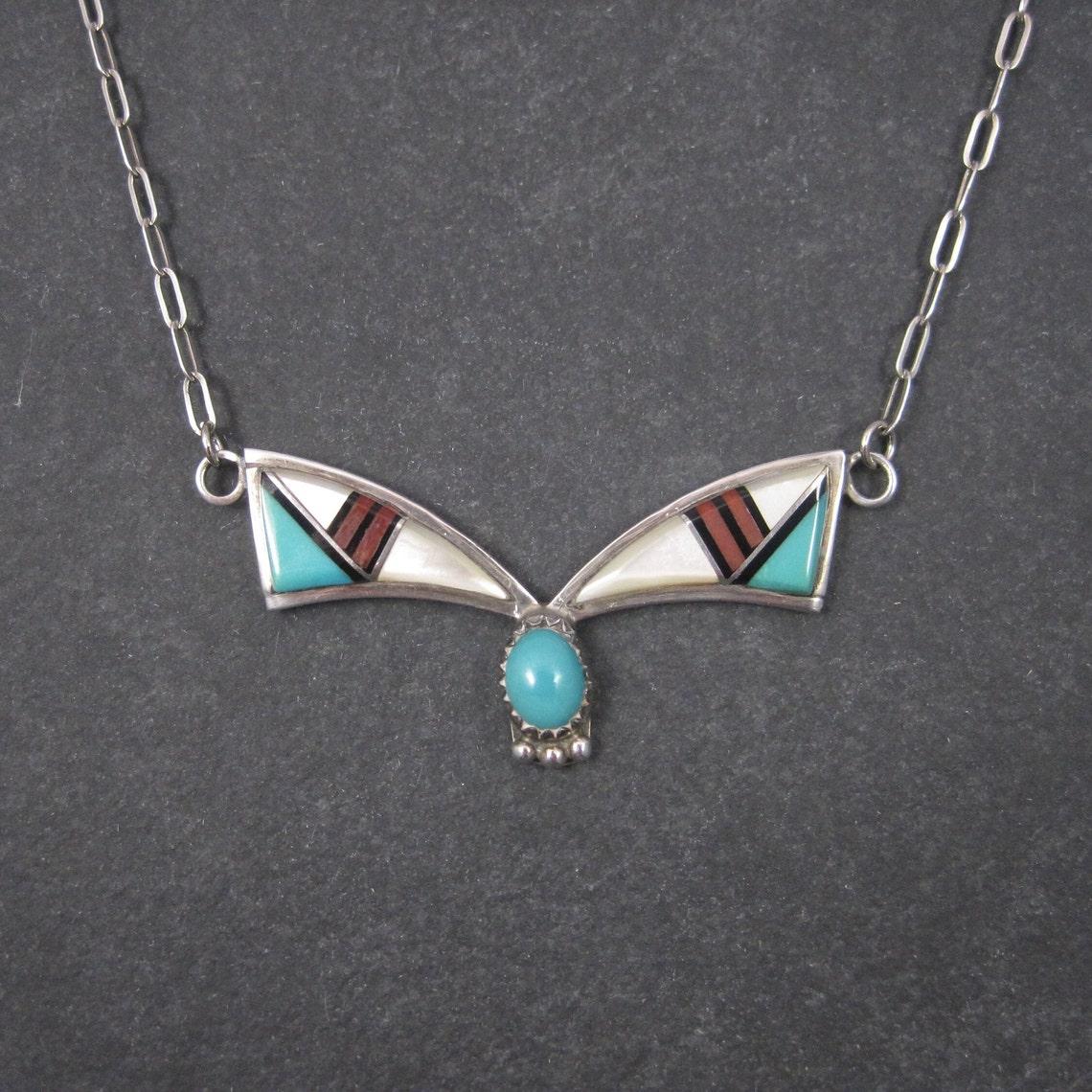 This beautiful vintage Southwestern necklace is sterling silver with turquoise, jet, coral and mother of pearl inlay.

The pendant part of this necklace measures 3/4 by 2 inches.
The necklace measures 18 inches from end to end.

Marks: