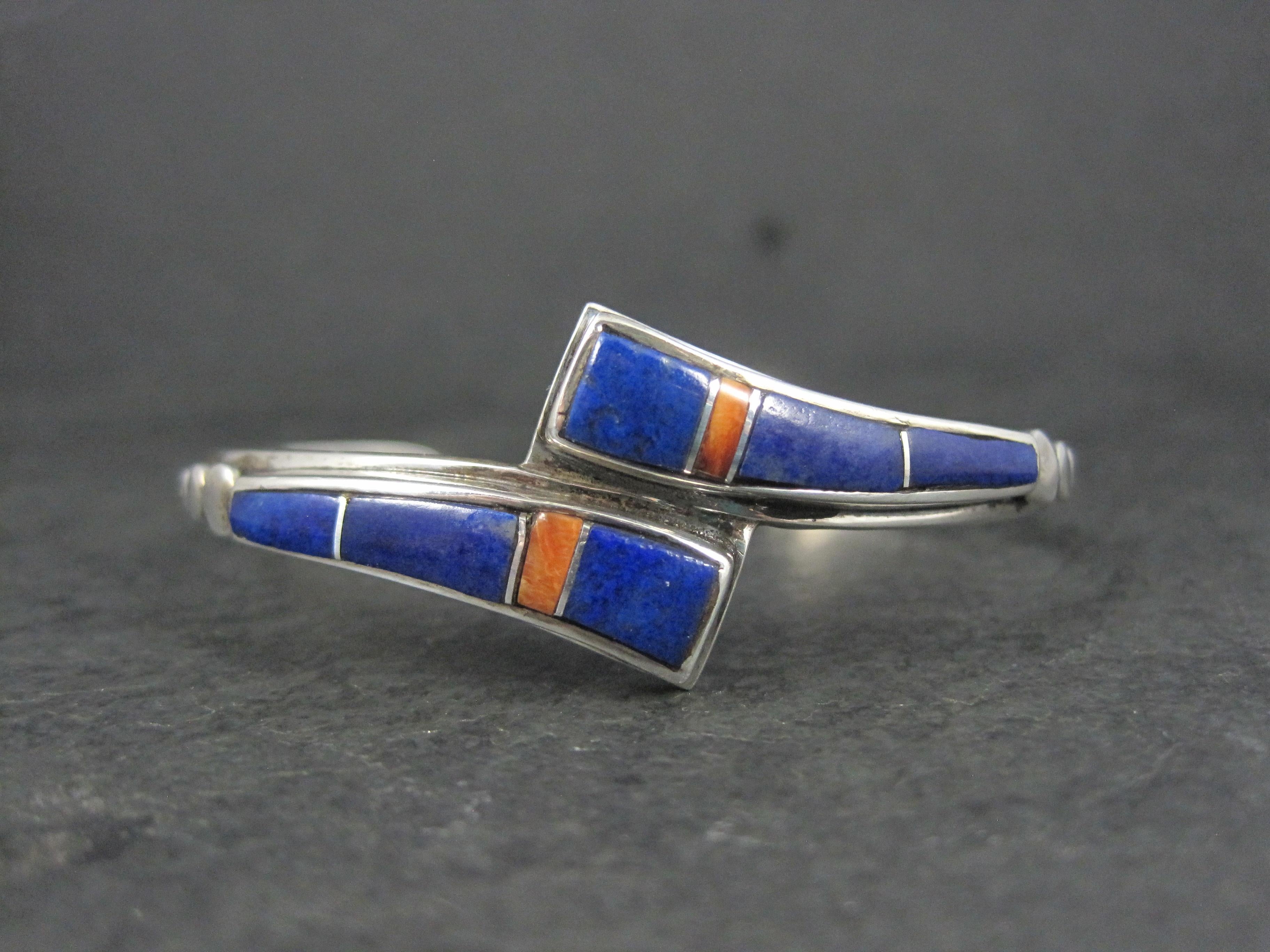 This gorgeous vintage Southwestern cuff bracelet is sterling silver with lapis lazuli and spiny oyster inlay.
The face of this cuff measures 13/16 of an inch north to south.
It has an inner circumference of 6 inches, including the 1 inch
