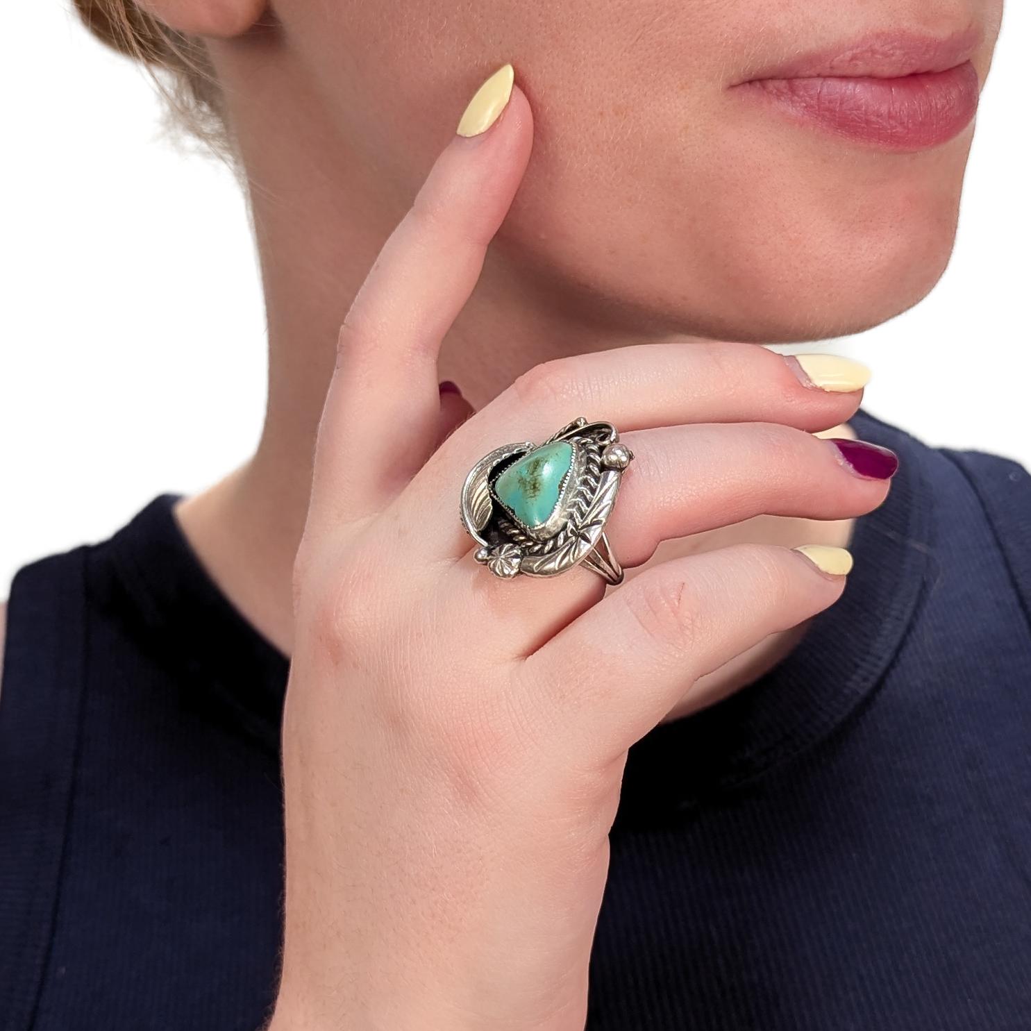 Un bell'anello del Sud-Ovest.

In argento sterling.

In stile sud-occidentale (Navajo).

Lunetta incastonata con un cabocho triangolare di turchese. La montatura in argento con una foglia figurata in rilievo e una decorazione geometrica incisa è