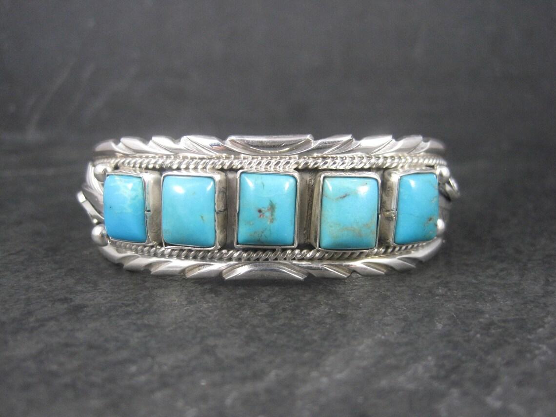 This gorgeous estate cuff bracelet is sterling silver with 5 turquoise gemstones.

Measurements: 13/16 of an inch wide.
It has an inner circumference of 6 inches including a 3/4 of an inch gap.

Weight: 34.3 grams

Marks: D, Sterling

Condition: