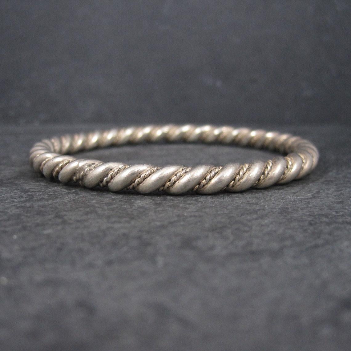 Diese schöne südwestliche Armspange ist aus Sterlingsilber.
Es zeichnet sich durch ein gedrehtes Seilmuster aus.

Abmessungen: 1/4 Zoll (6 mm) breit, Innenumfang von 7 3/4 Zoll, Innendurchmesser von 2 1/2 Zoll

Gewicht: 47.9 Gramm
