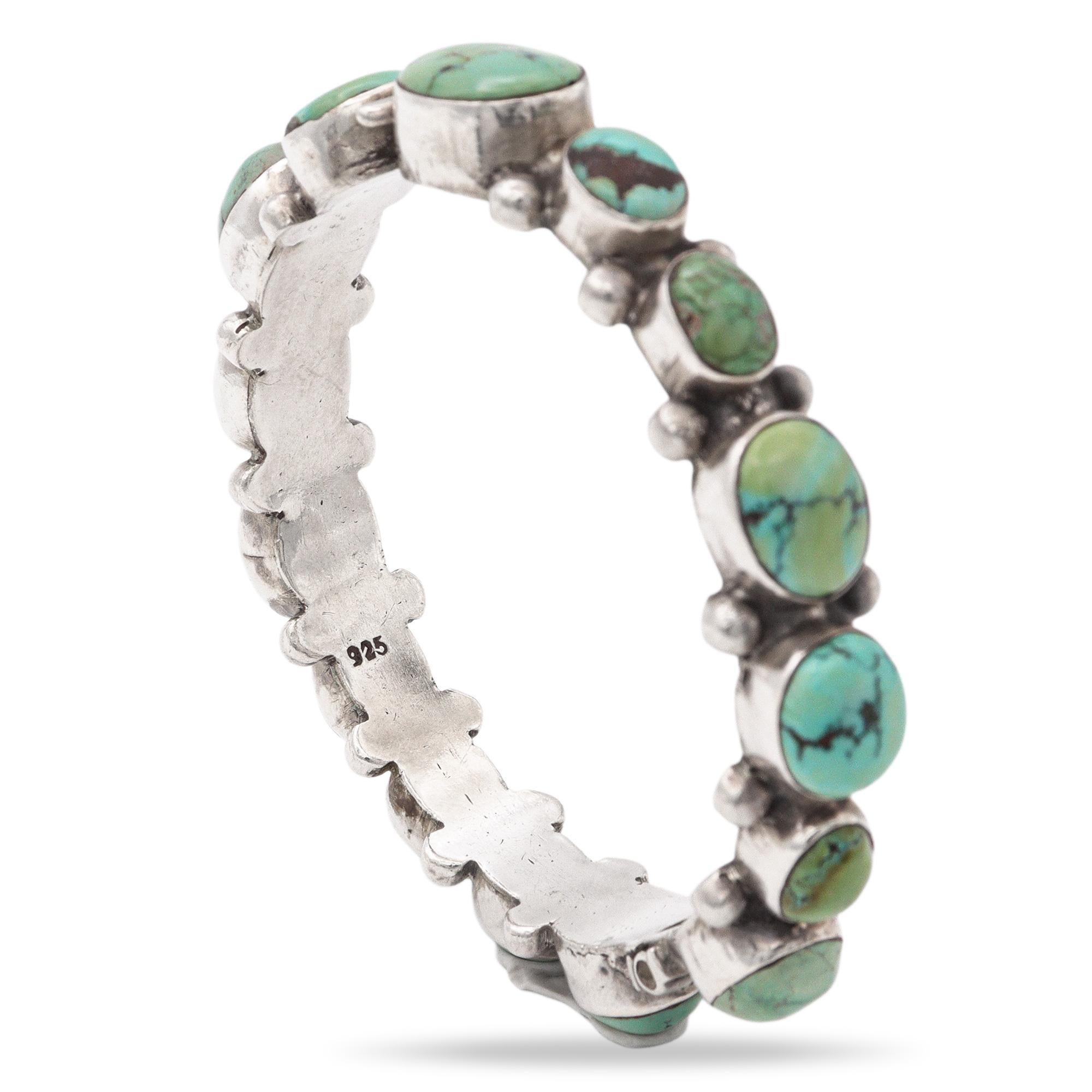 A beautiful fusion of craftsmanship and natural stone beauty, this sterling silver hinged bangle is adorned with vibrant turquoise cabochons. Each stone is uniquely patterned with natural matrix, showcasing the individuality and organic charm of