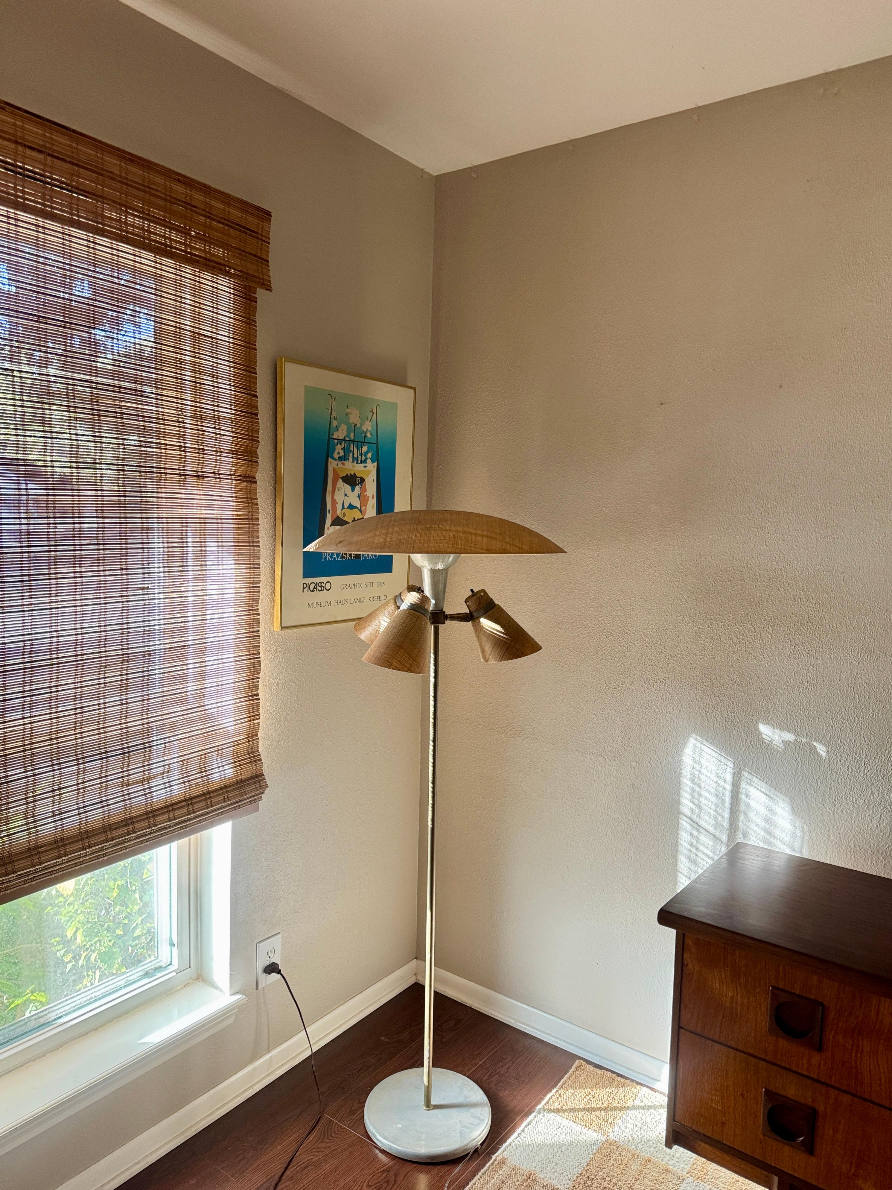 Lampadaire vintage NO AGE à 4 lumières, circa 1960. Le design se caractérise par un cadre métallique substantiel avec des tons argentés et dorés magnifiquement patinés et des abat-jours en fibre de verre. Trois cônes sculpturaux s'illuminent sur les