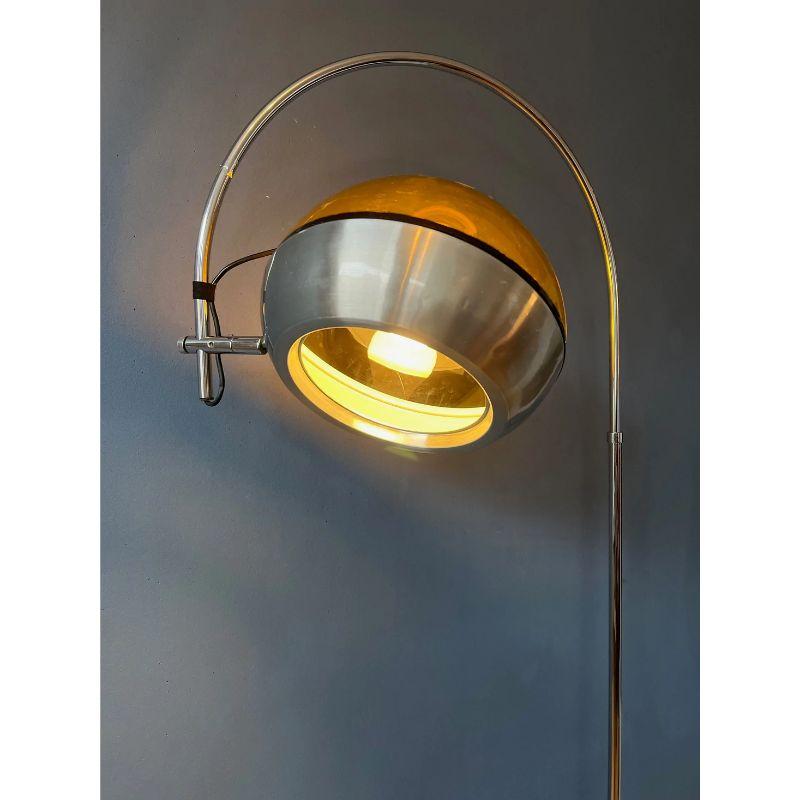 A very special space age arc floorlamp by Dijkstra. It has a transparent shade in a dark copper/bronze colour, which rests on the lower aluminium part of the shade. The shade can be turned in different directions and can move inside or outside the