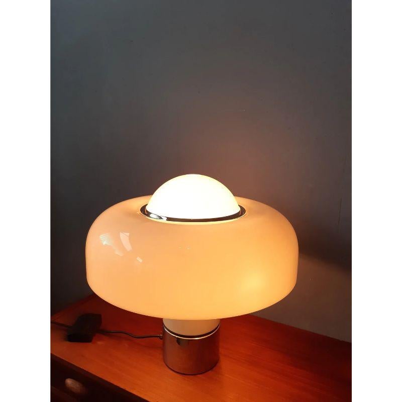 An original Guzzini Brumbry / Brumbury table lamp designed by Luigi Massoni for Guzzini. This iconic lamp in its white edition produces a classy, warm light. The lamp requires four E14 lightbulbs: 1 right underneath the shade and 3 on the side of